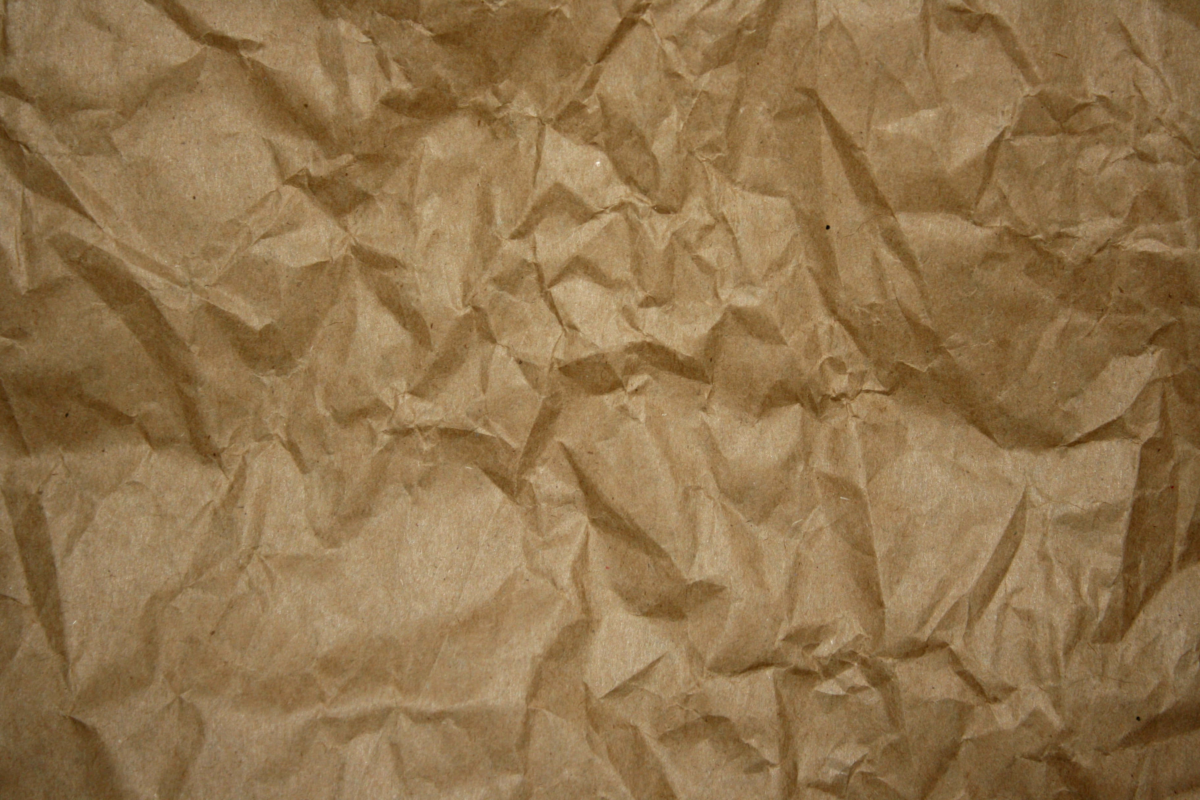 Brown Paper 桌布 壁紙 — 柔和燈光下，帶有深摺痕和自然皺褶的紋理棕色紙張特寫。