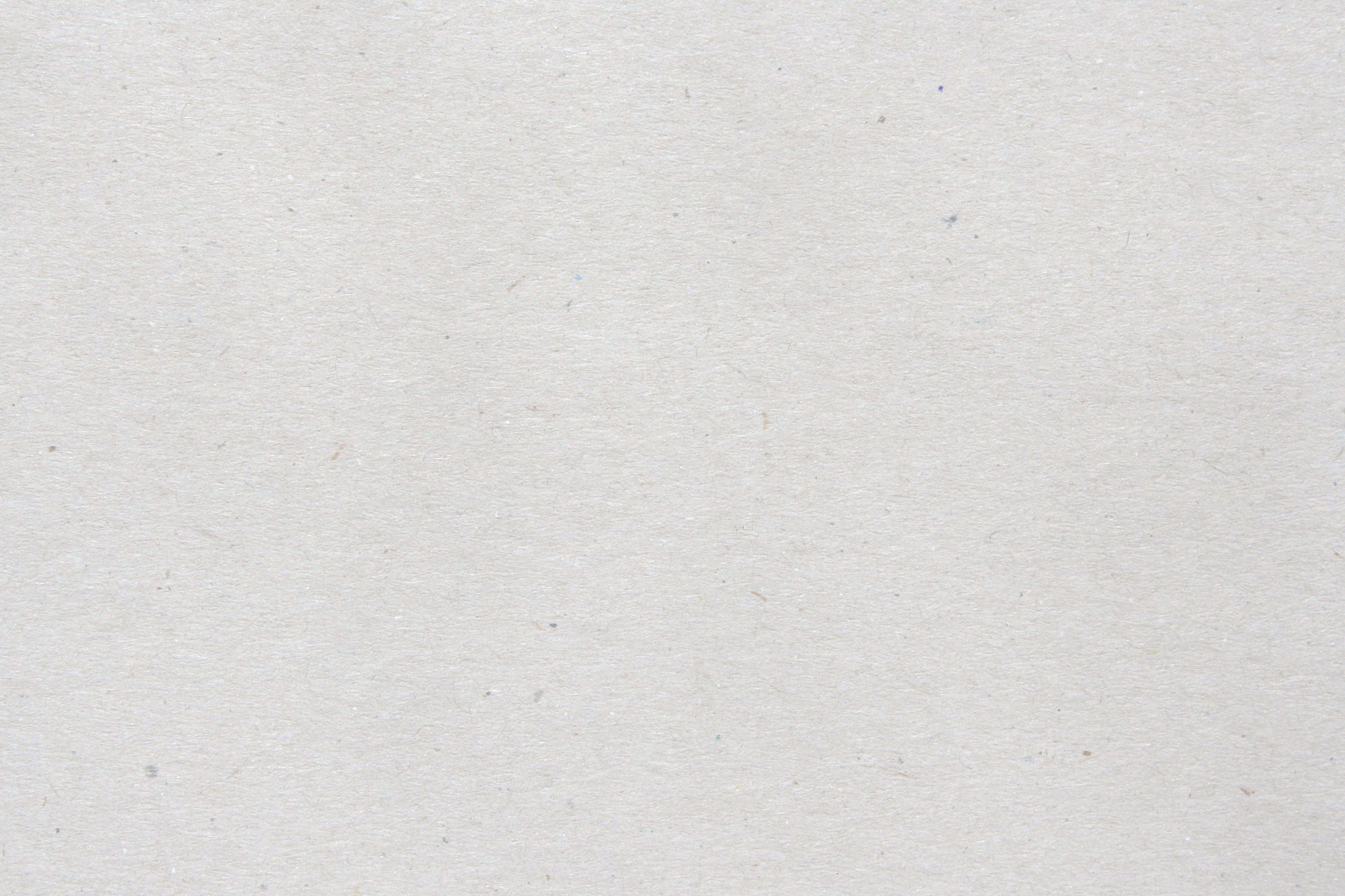 White Paper 桌布 壁紙 — 柔和燈光下，帶有細微斑點和纖維的紋理米白色紙張特寫。
