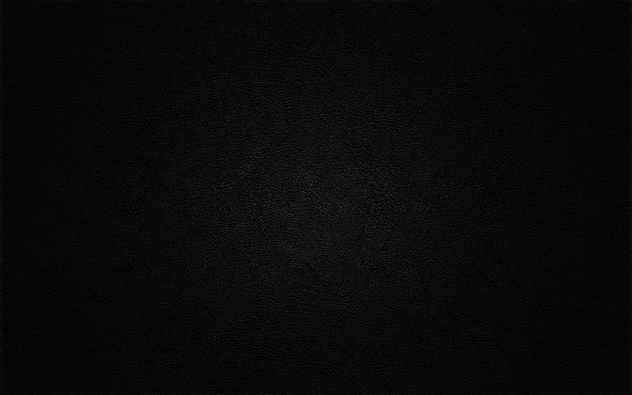 Plain Black Desktop 桌布 壁紙 — 柔和燈光下光滑黑色皮革表面的特寫，帶有細微粒面紋理。