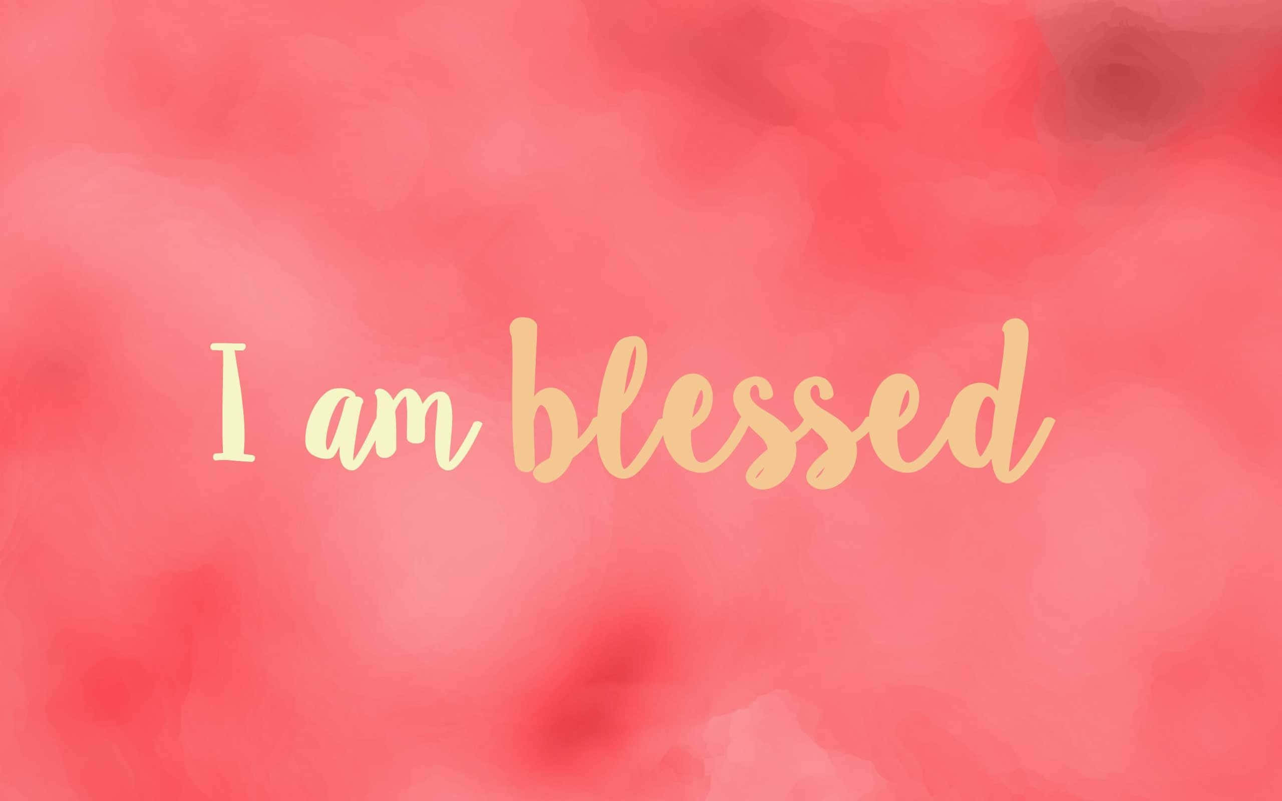 粉紅色 桌布 壁紙 — 柔和珊瑚水彩背景，中央有金色草書文字 'I am blessed'。