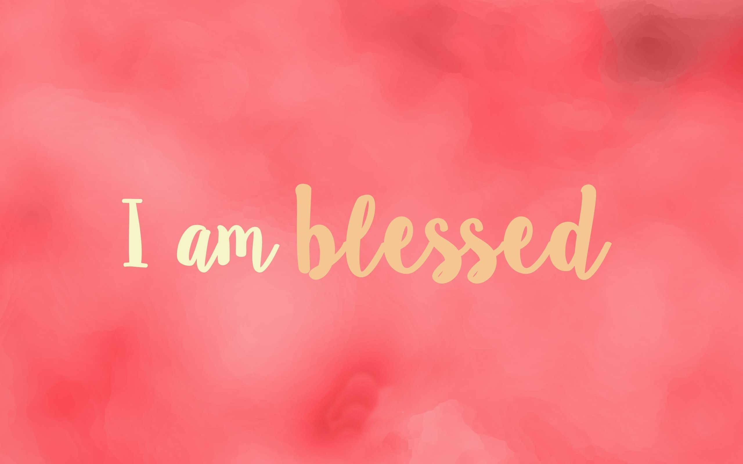 blessed 桌布 壁紙 — 柔和珊瑚水彩背景，中央有金色草書文字寫著「I am blessed」。