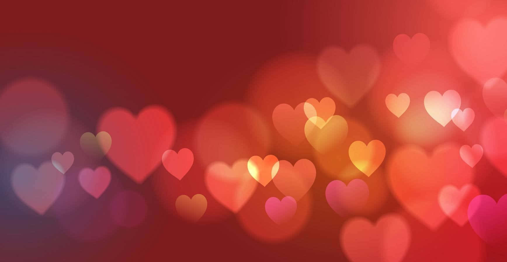 valentine 桌布 壁紙 — 柔和發光的愛心，以溫暖的紅色和粉紅色調，夢幻般漂浮在模糊的浪漫背景上。