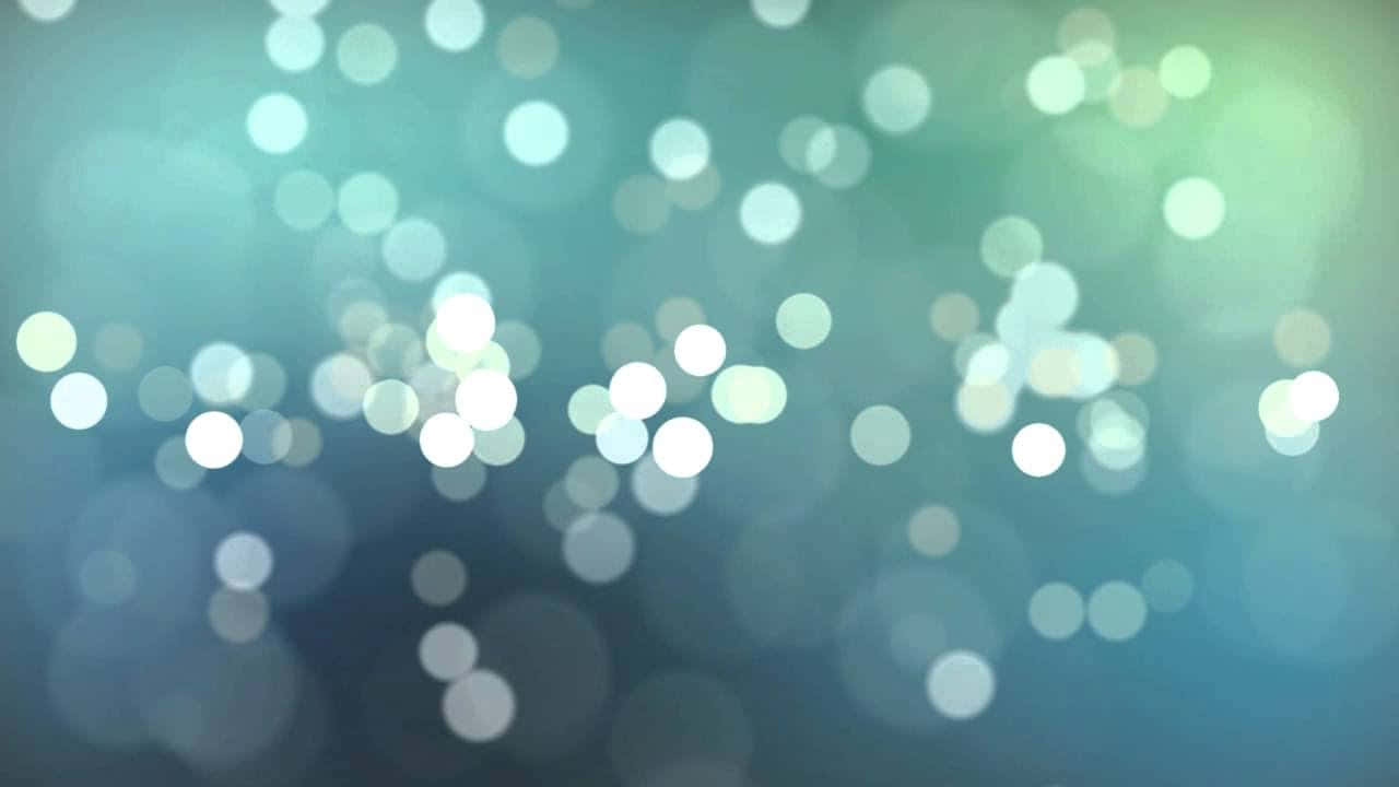 在藍綠色和藍色漸變背景上發光的散景燈光 — 影片 GIF 壁紙