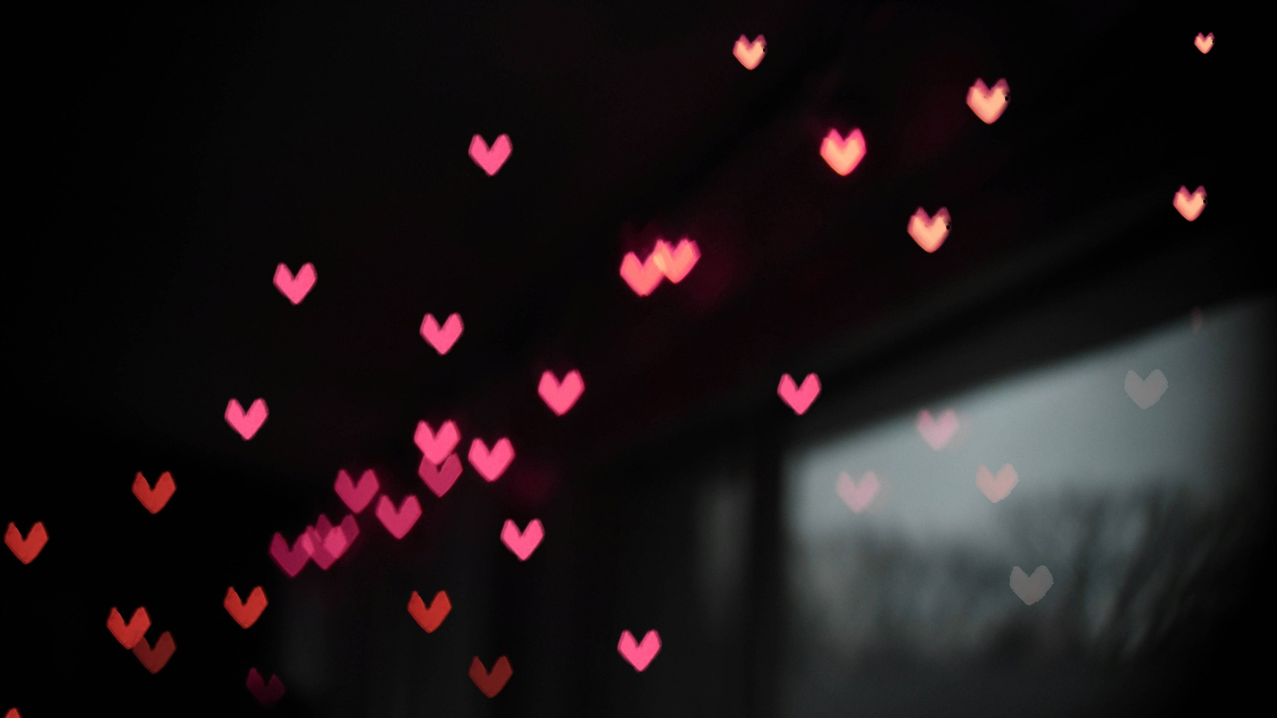 Dark Heart 桌布 壁紙 — 柔和發光的粉紅色心形散景燈光在黑暗的窗戶上漂浮，顯露出雨夜的場景。