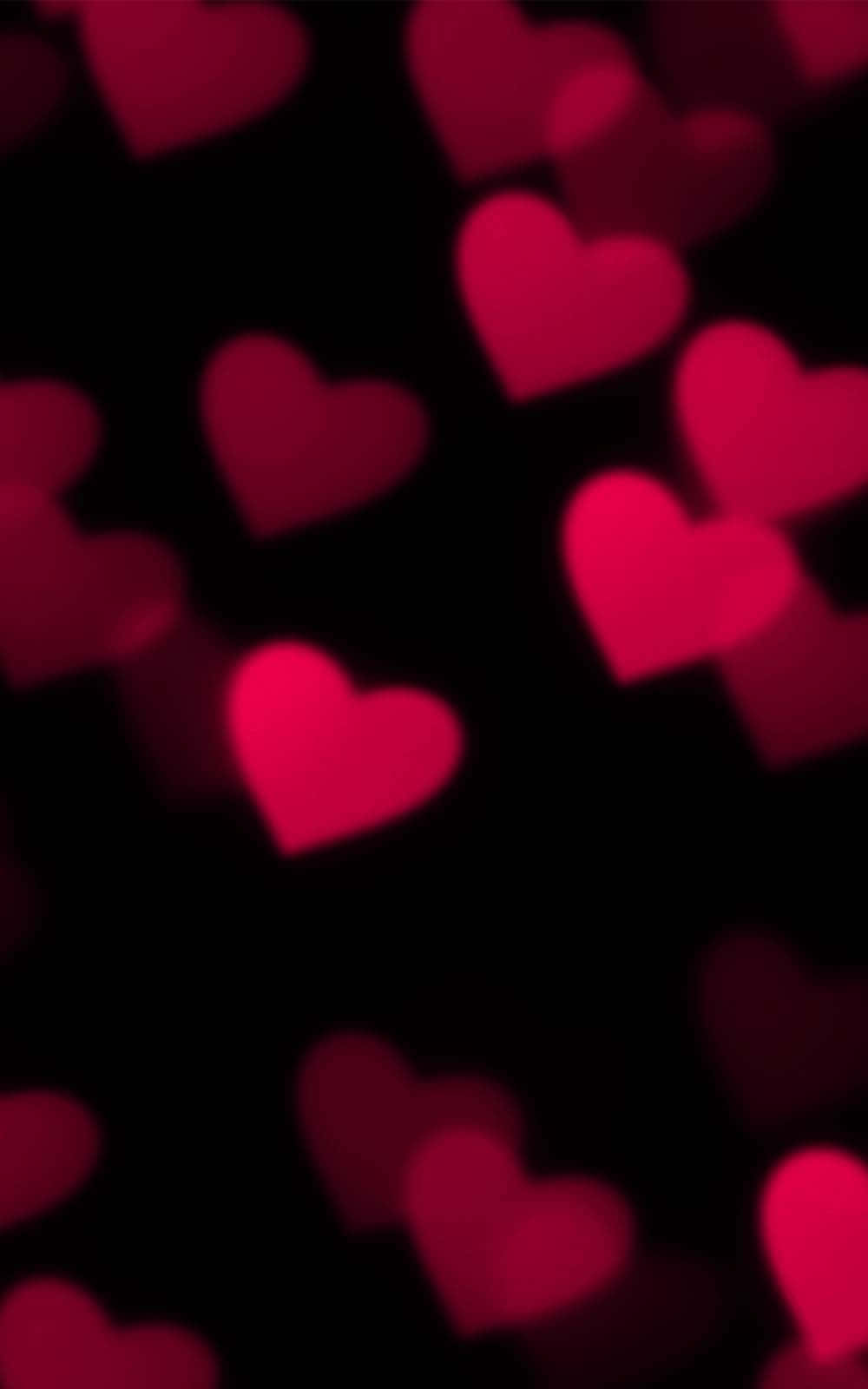 Pink Hearts 桌布 壁紙 — 柔和發光的紅色心形在深黑色背景上夢幻般漂浮，營造浪漫散景效果。