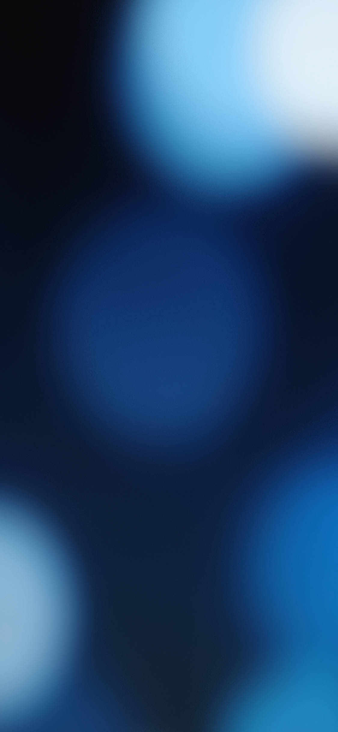 iOS 13 桌布 壁紙 — 柔和發光的藍色圓圈在深色背景上柔和地模糊，營造出夢幻般的抽象氛圍。