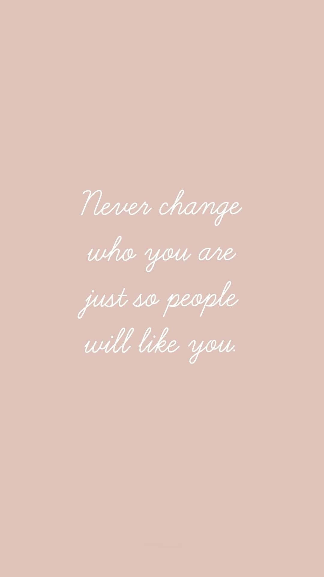 桌布 壁紙 — 柔和的桃色背景上，優雅的白色草書字體寫著「Never change who you are just so people will like you。」