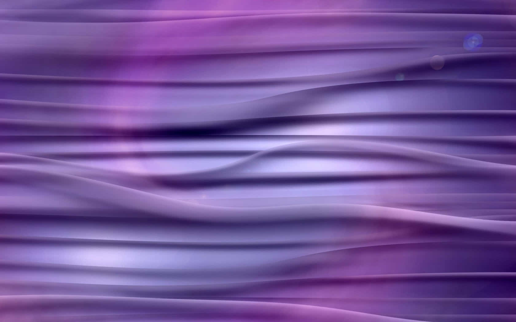 Purple Silk 桌布 壁紙 — 柔和的流動紫色波浪，帶有發光高光和鏡頭光暈，營造出夢幻般的抽象數位紋理。
