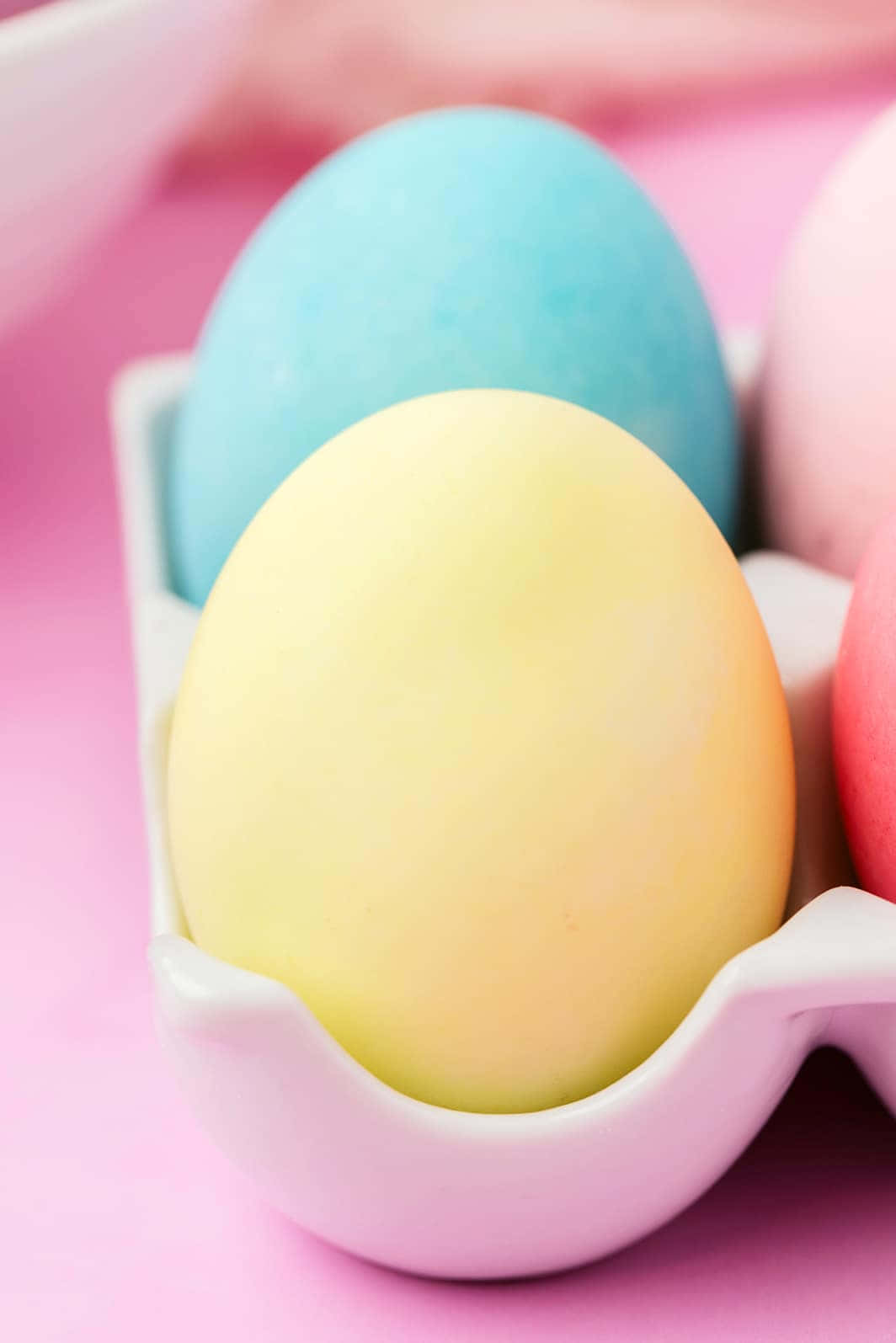 Eggs 桌布 壁紙 — 柔和的粉彩復活節蛋放在粉紅色陶瓷架中，襯托夢幻粉紅背景。