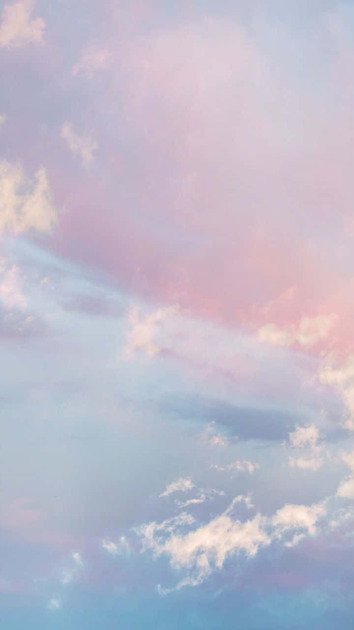 雲朵 桌布 壁紙 — 柔和的粉彩雲在暮色中飄過寧靜的天空，天空塗上溫柔的粉紅、藍色和紫色。