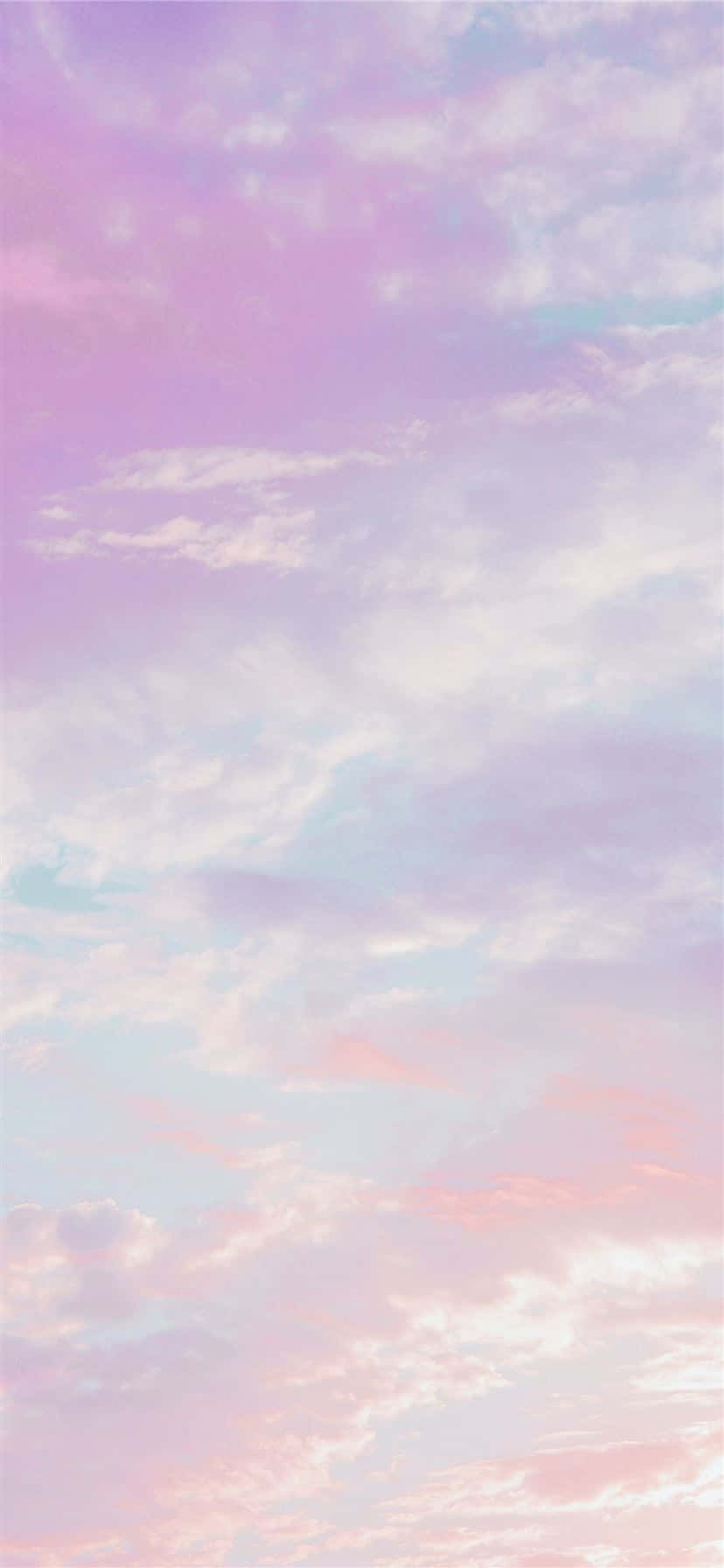 Pink And Blue Clouds 桌布 壁紙 — 柔和的粉彩雲朵飄過夢幻般的天空，塗上溫柔的粉紅、薰衣草和藍色。