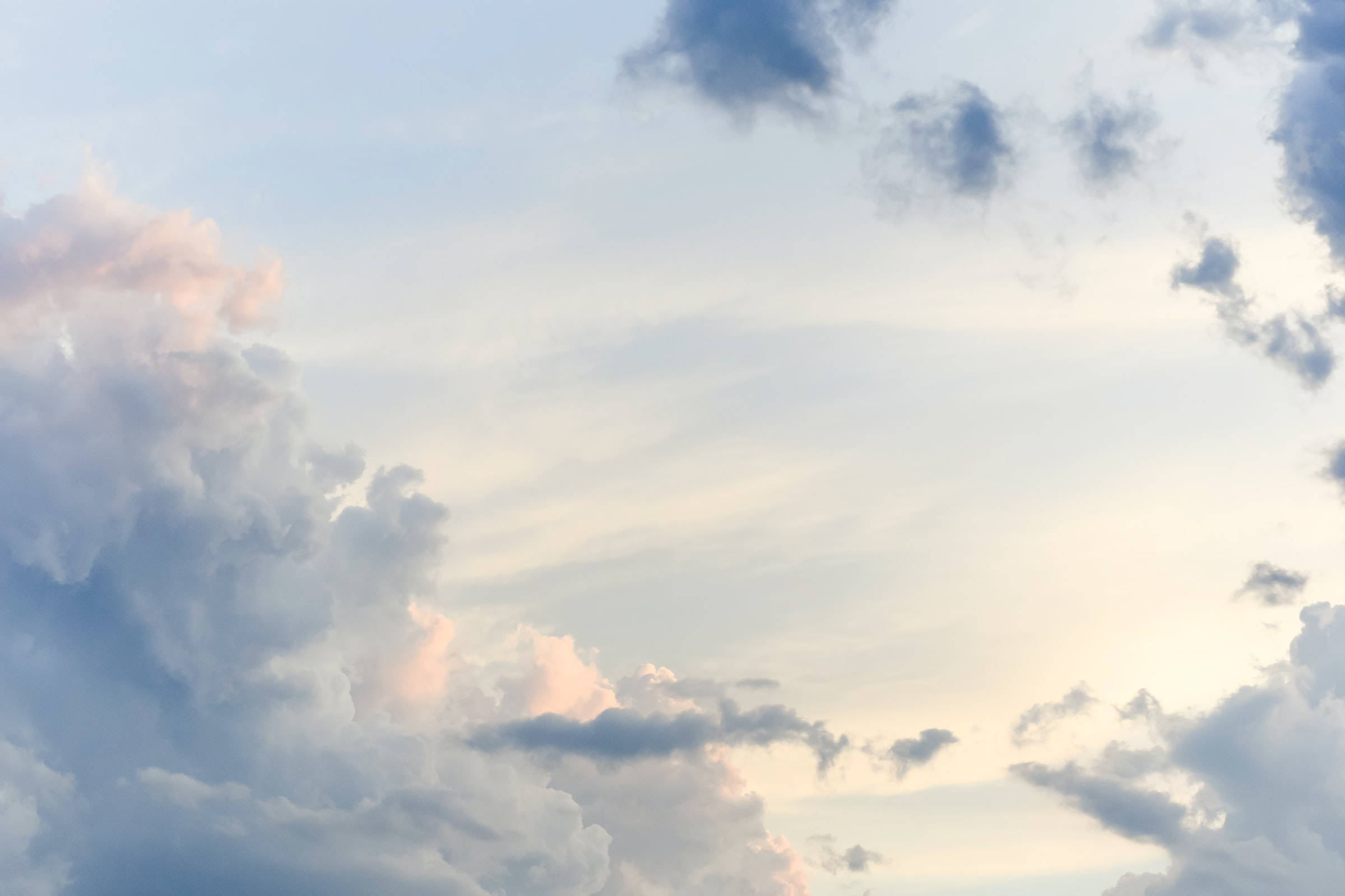 Clouds Aesthetics 桌布 壁紙 — 柔和的粉彩雲朵飄過寧靜的天空，散發著溫暖的日落色調。