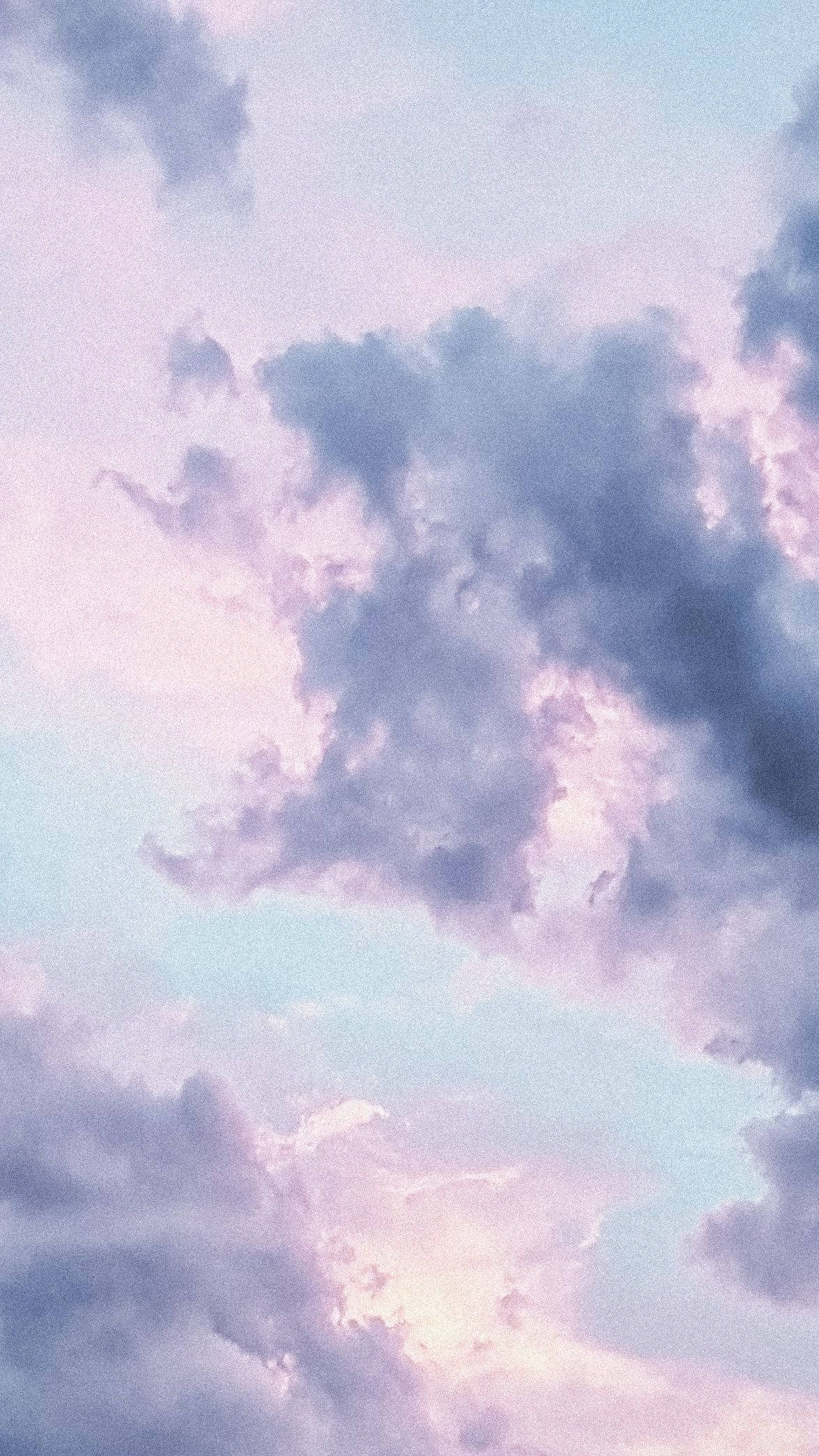 Pink And Blue 桌布 壁紙 — 柔和的粉彩雲朵飄過寧靜的天空，融合了薰衣草藍和蜜桃色調。