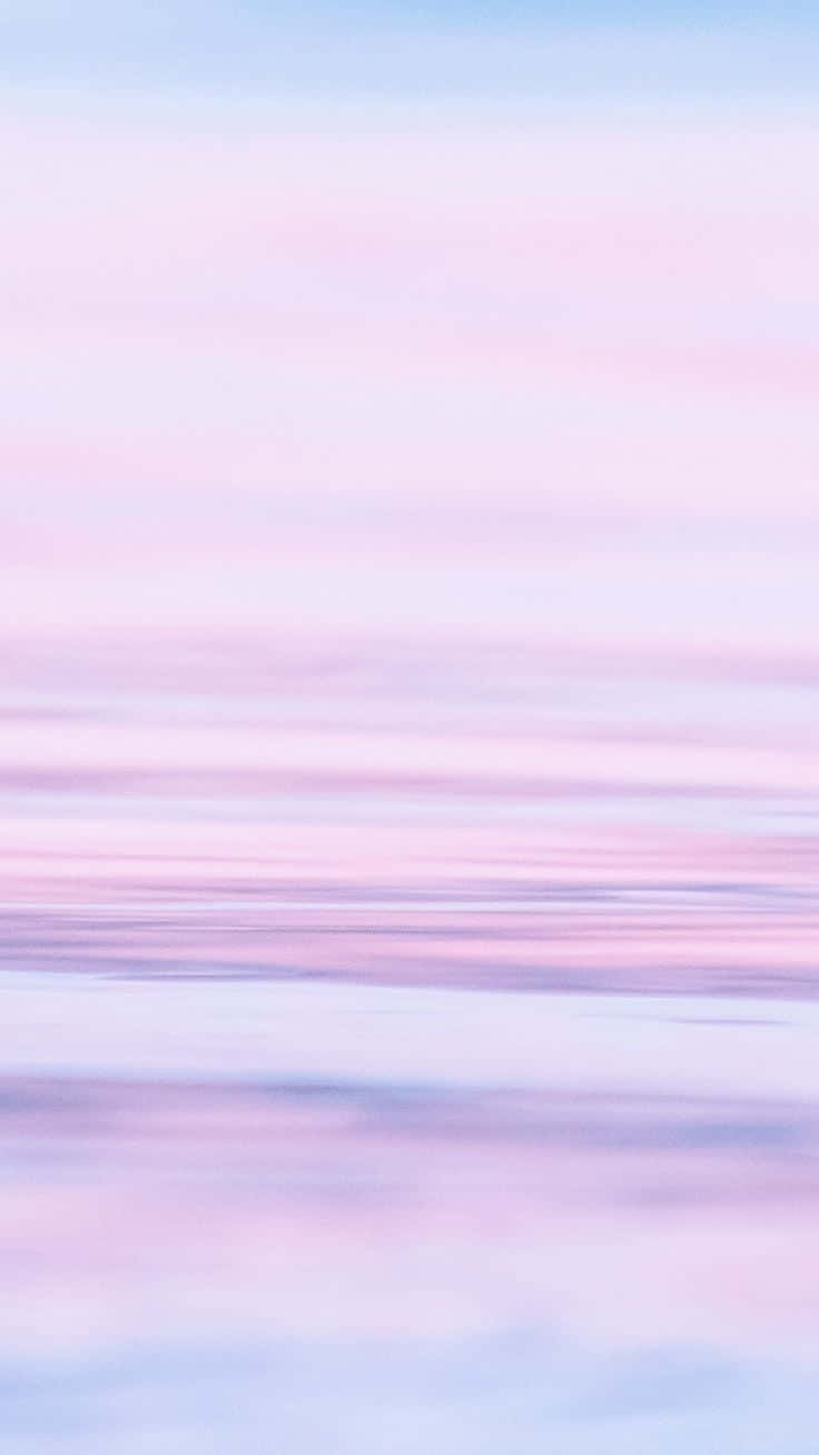 Pastel Blue And Pink 桌布 壁紙 — 柔和的粉紅和粉藍色雲彩在寧靜的天空中劃過，帶有輕柔的水平動態模糊效果。