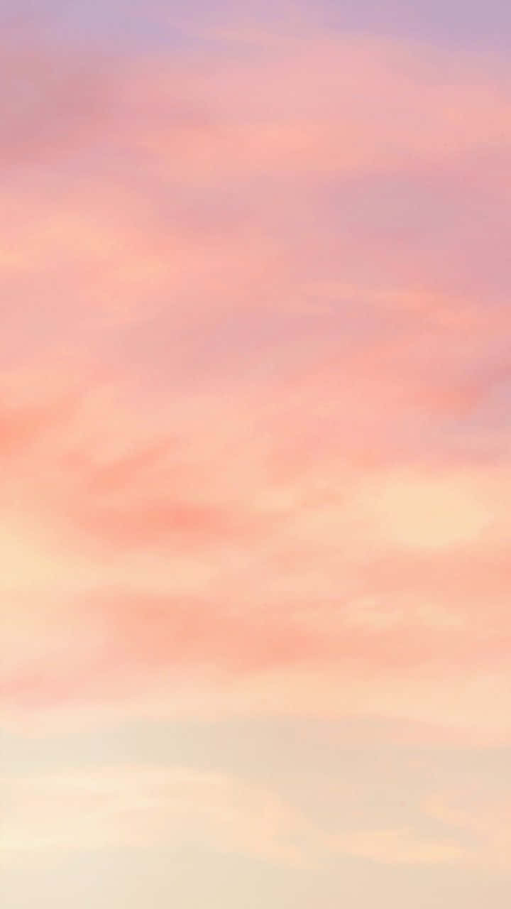 桌布 壁紙 — 柔和的粉紅和蜜桃色雲朵在寧靜的暮色天空中飄蕩，帶有柔和的漸變。