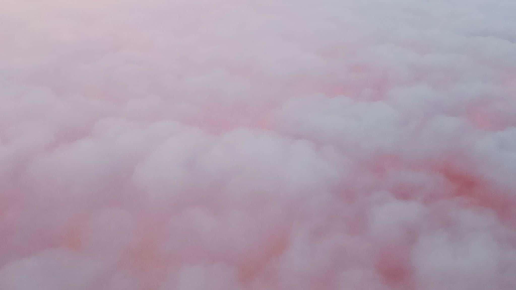糖果 桌布 壁紙 — 柔和的粉紅色和白色雲朵在夢幻的天空中飄浮，帶有柔和的漸變和蓬鬆的質感。
