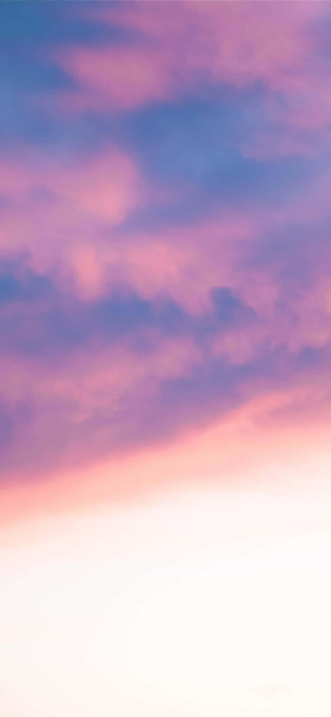 Aesthetic Sky 桌布 壁紙 — 柔和的粉紅色和紫色雲彩在日落時分的明亮天空中飄移。