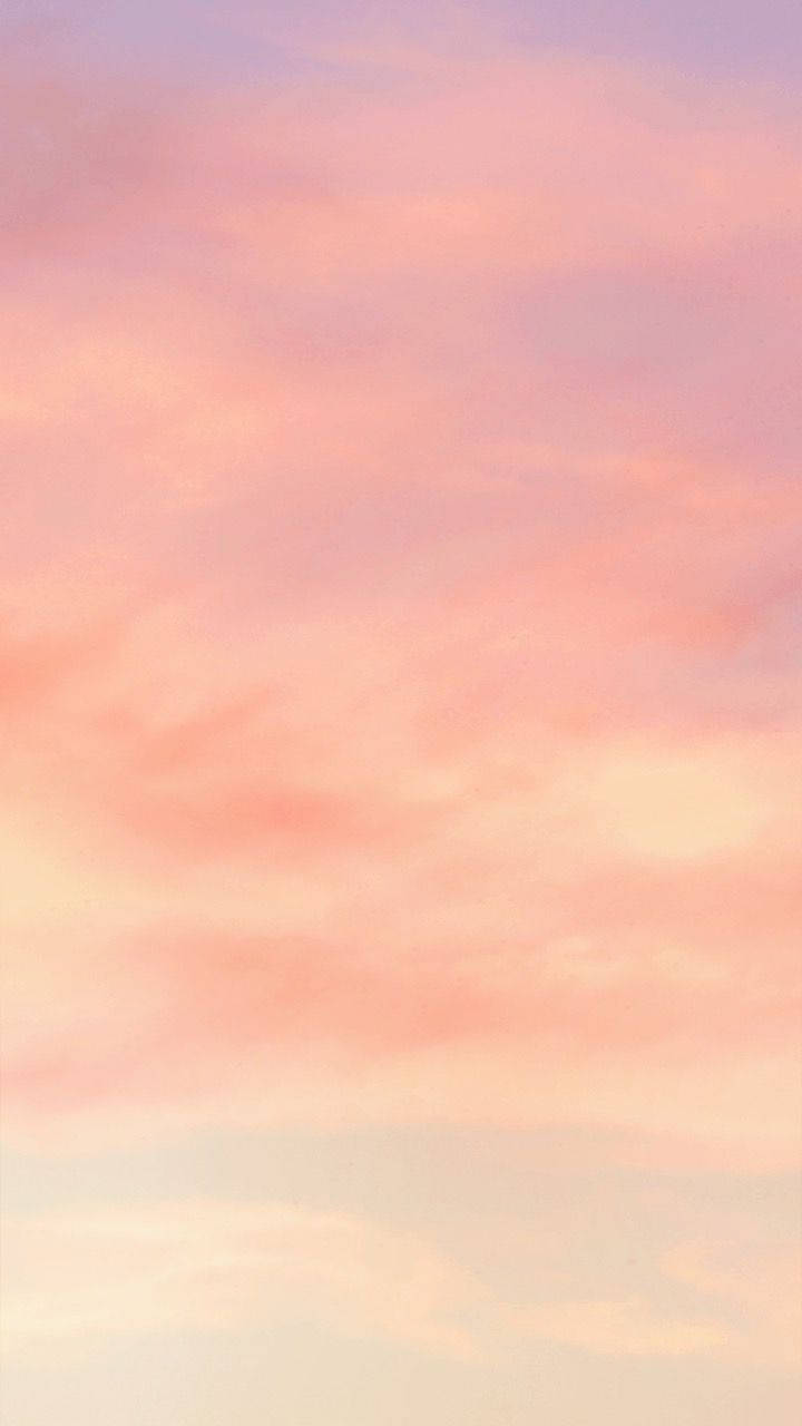 iPhone 桌布 壁紙 — 柔和的粉紅色和薰衣草色雲彩在黎明或黃昏時分飄過寧靜的天空。