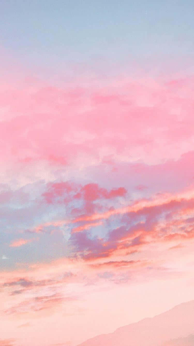 Pink Sky 桌布 壁紙 — 柔和的粉紅色和藍色雲彩在黃昏時飄過遠山，營造出夢幻的粉彩天空。