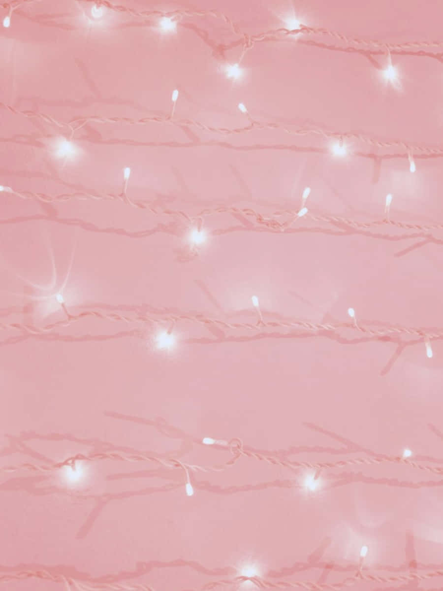 Pink And White Aesthetic 桌布 壁紙 — 柔和的粉紅色背景，點綴著發光的白色串燈，營造出溫馨夢幻的氛圍。