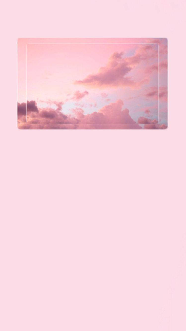 iPhone Pink Aesthetic 桌布 壁紙 — 柔和的粉紅雲朵在白色邊框內發光，映襯著暮色中的粉彩天空。