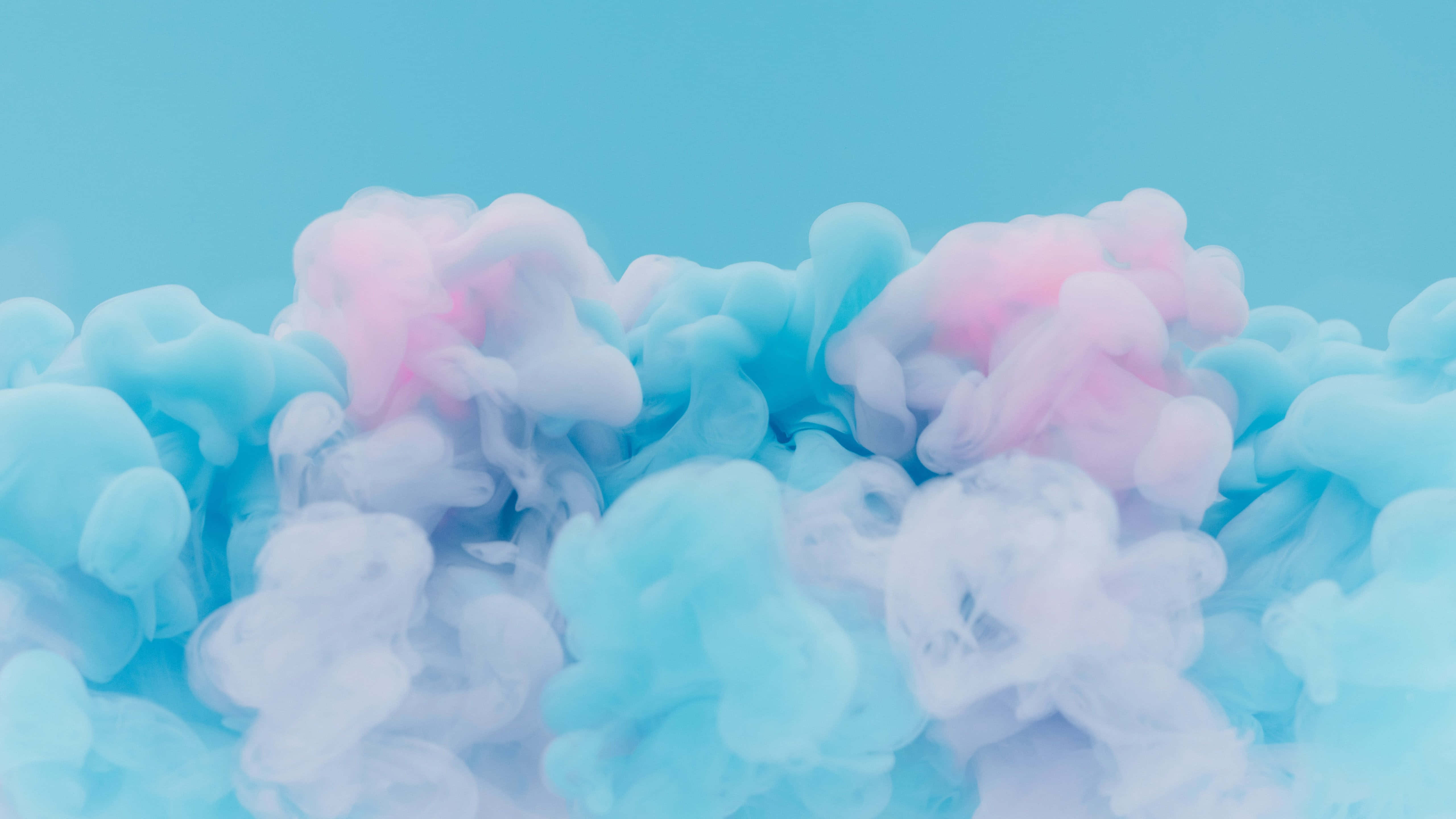 Pink Blue 桌布 壁紙 — 柔和的粉藍色和粉紅色墨水漩渦在純青色背景上輕輕擴散，形成夢幻般的抽象構圖。