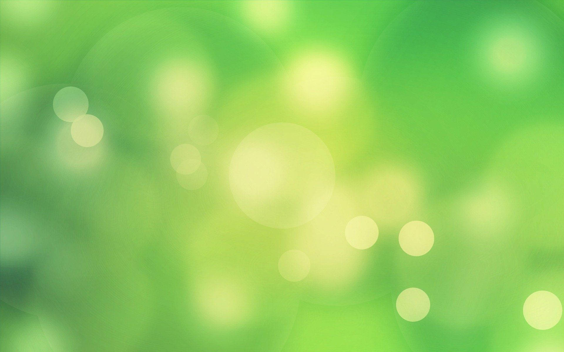 綠色 桌布 壁紙 — 柔和的綠色散景燈光在模糊的自然背景下輕輕發光，營造出寧靜夢幻的氛圍。