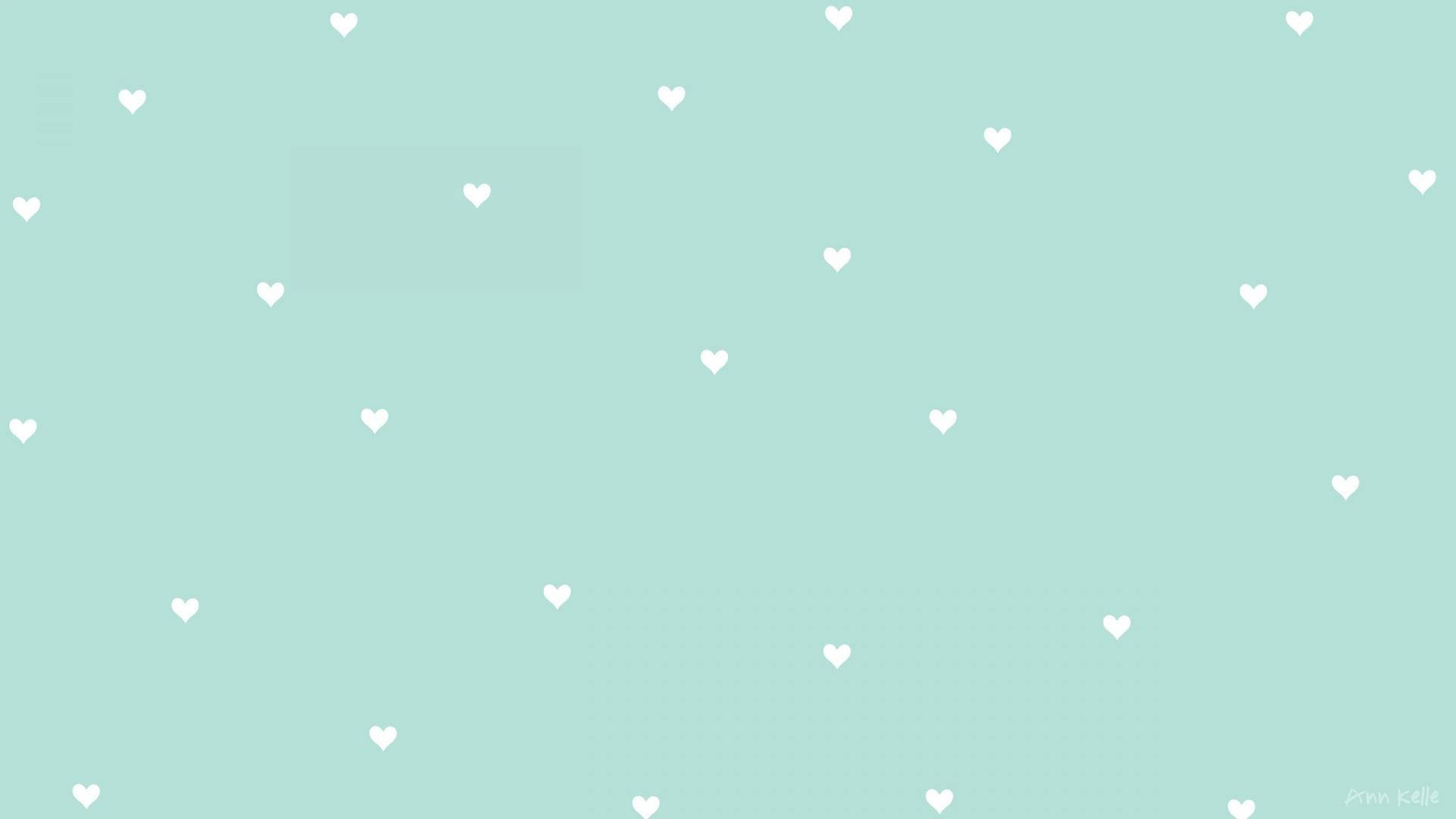 Pastel Green Aesthetic Laptop 桌布 壁紙 — 柔和的薄荷綠色背景，點綴著散落的白色愛心，呈現極簡數位圖案。