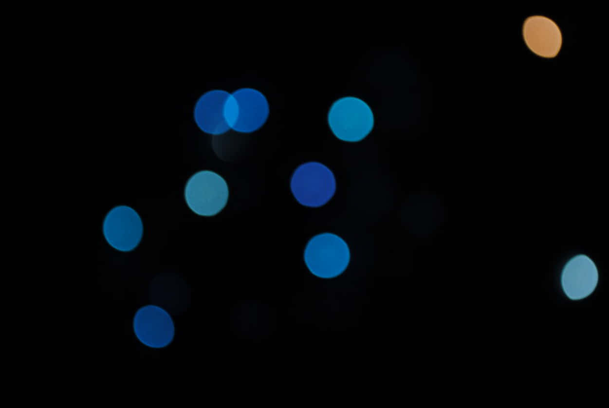 Dot Texture 桌布 壁紙 — 柔和的藍色和橙色散景燈光在深黑色背景上閃爍，營造出夢幻般的夜晚氛圍。