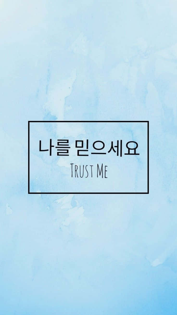 Aesthetic Korean 桌布 壁紙 — 柔和的藍色水彩背景上有一個黑色邊框的盒子，裡面有韓文文字 나를 믿으세요 和英文文字 TRUST ME。