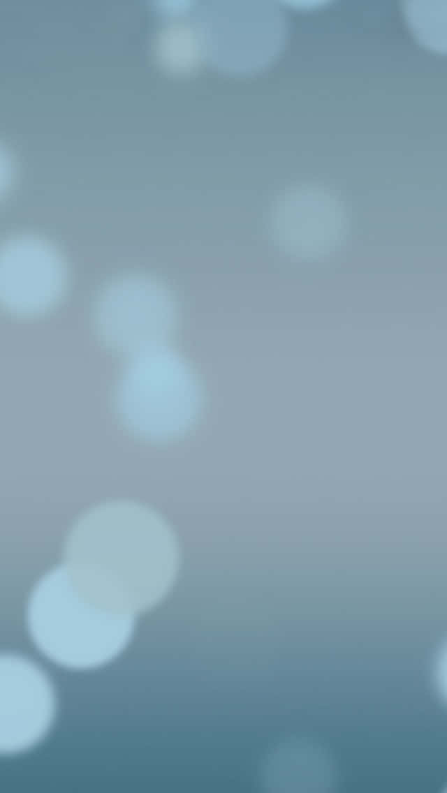 iOS 4 桌布 壁紙 — 柔和的藍色漸層背景，散落著失焦的光圈，營造出夢幻般的散景效果。