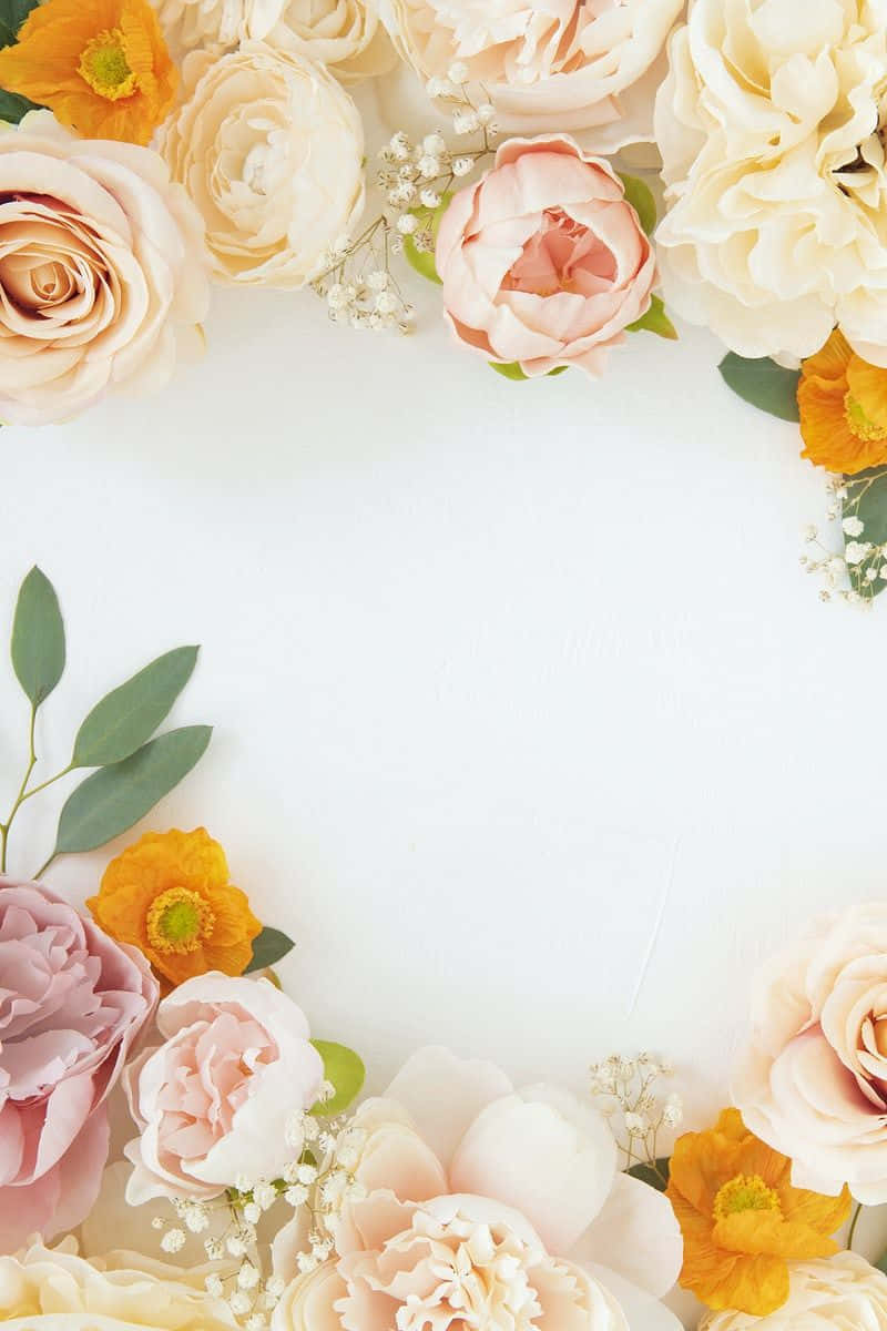 Floral Wreath 桌布 壁紙 — 柔和的蜜桃粉紅和黃色的粉彩花朵，配上精緻的綠色點綴，圍繞著一個空白的白色空間。