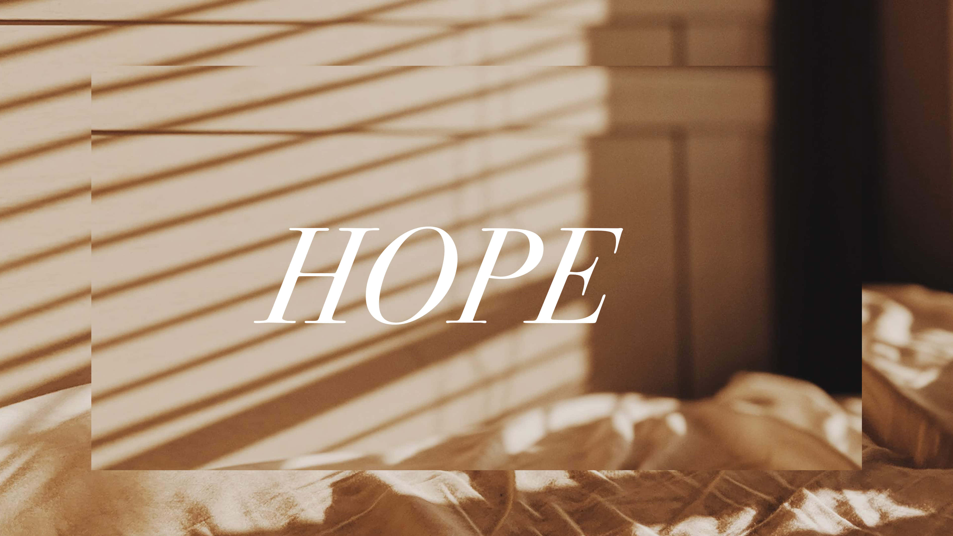 hope 桌布 壁紙 — 柔和的金色光線穿過百葉窗，在凌亂的床上投下條紋陰影，HOPE 這個詞優雅地居中。