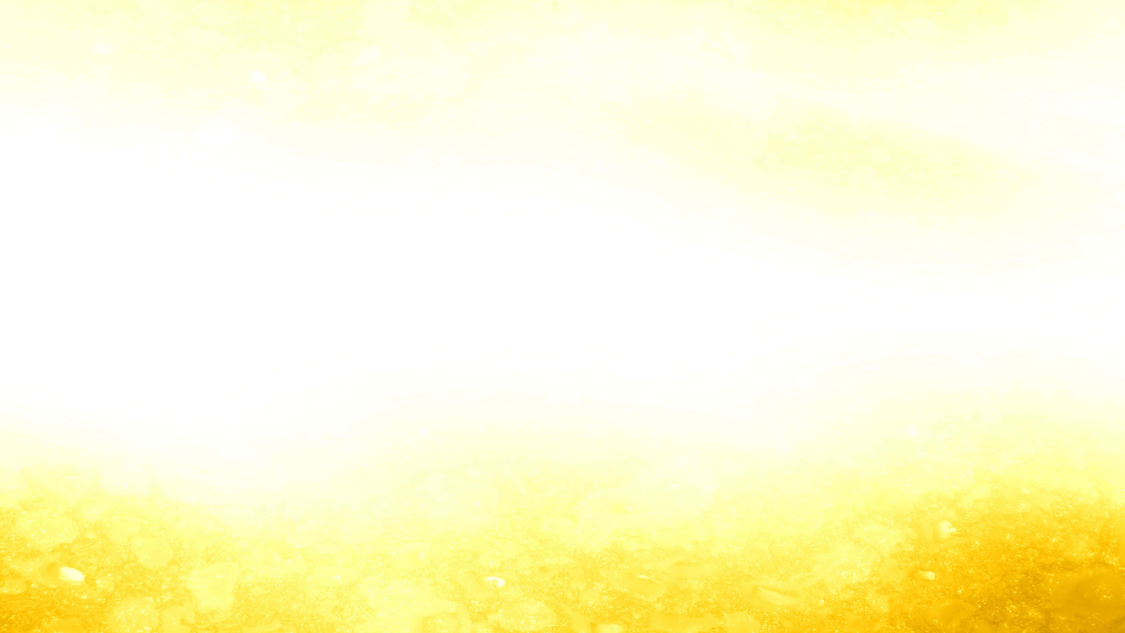 Yellow Grunge 桌布 壁紙 — 柔和的金色光芒從底部散發，帶有發光粒子並向上漸變為明亮的白色。