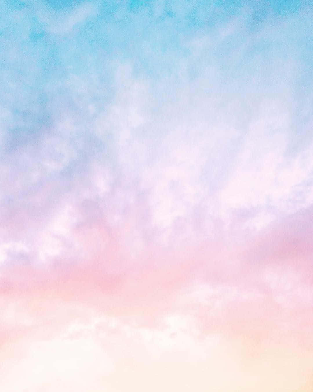 雲朵 桌布 壁紙 — 柔和粉彩天空，溫柔雲朵混合粉紅、藍色和蜜桃色調，形成夢幻漸變。