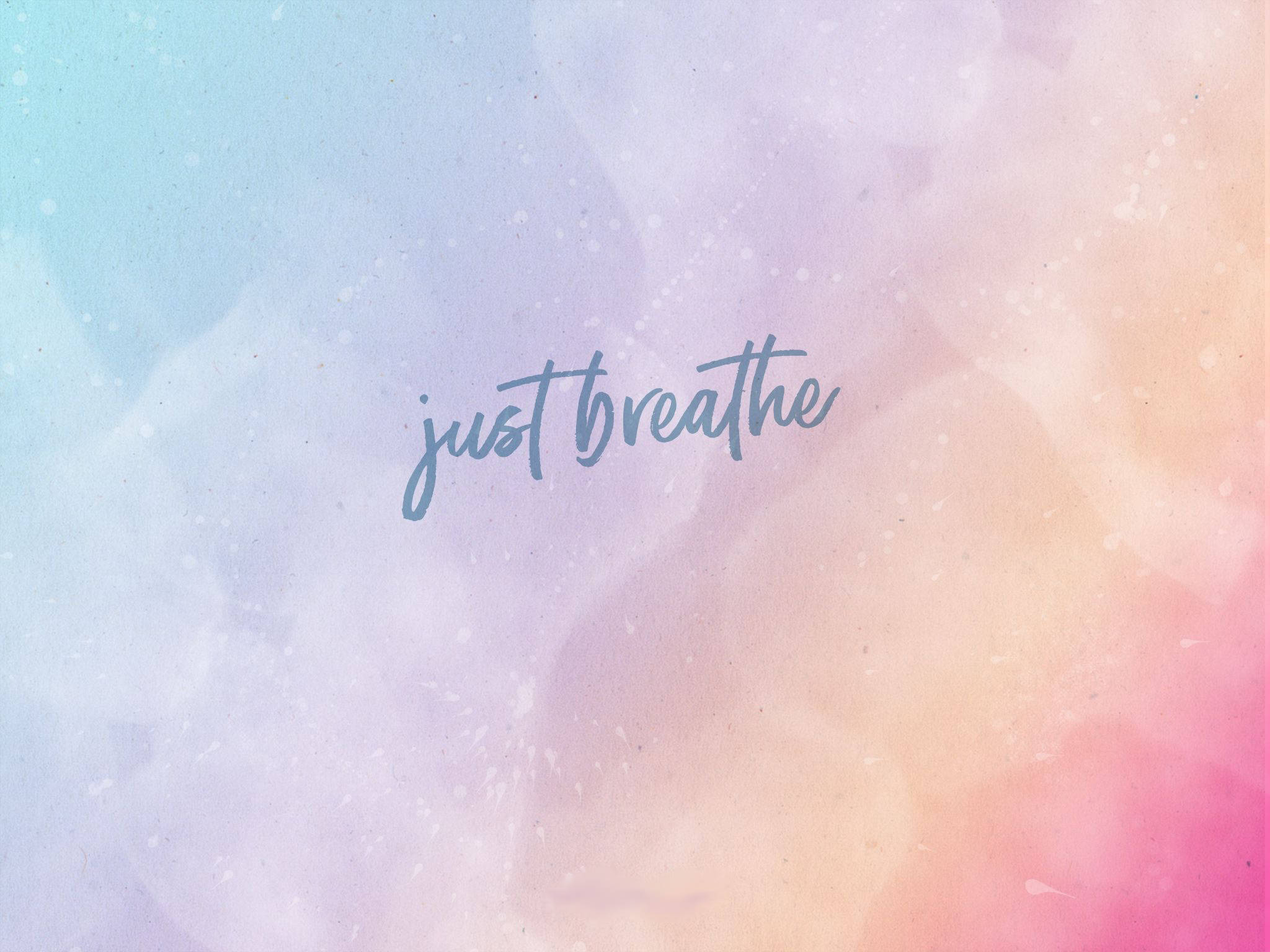 Breathing 桌布 壁紙 — 柔和粉彩水彩漸變，帶有浮動斑點和草書文字，內容為 just breathe。