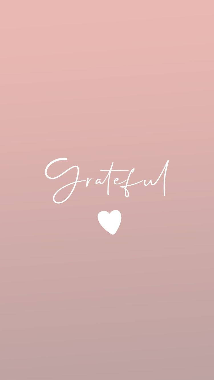 Thankful 桌布 壁紙 — 柔和粉紅漸變背景，以優雅白色草書呈現「Grateful」字樣，下方有一個小心形。