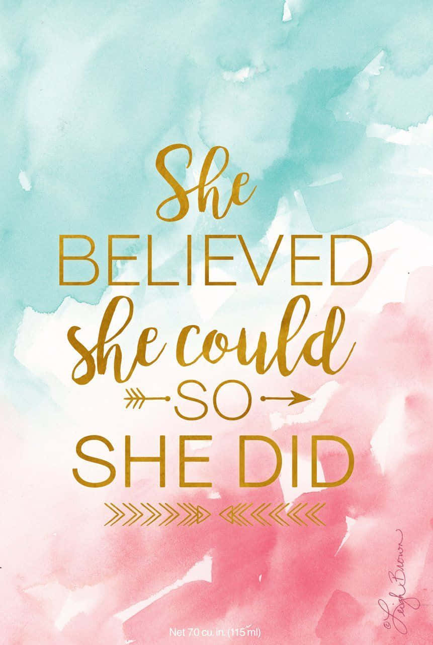 She Believed She Could 桌布 壁紙 — 柔和粉紅與青綠色水彩背景上的金色字體勵志名言。