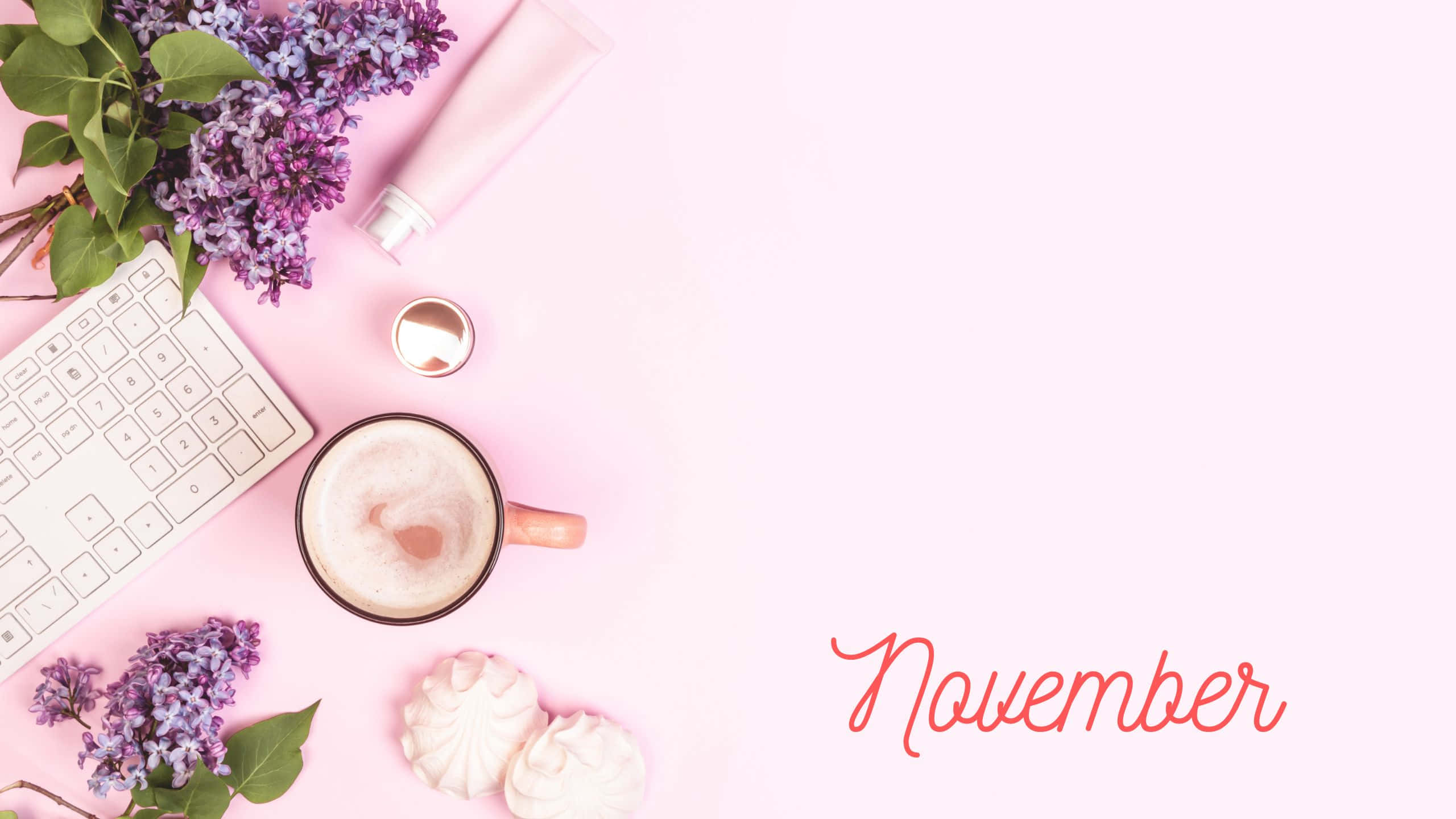 November Desktop 桌布 壁紙 — 柔和粉紅色平鋪構圖，包含紫丁香花、咖啡、鍵盤、馬卡龍，以及十一月字體，背景簡約。