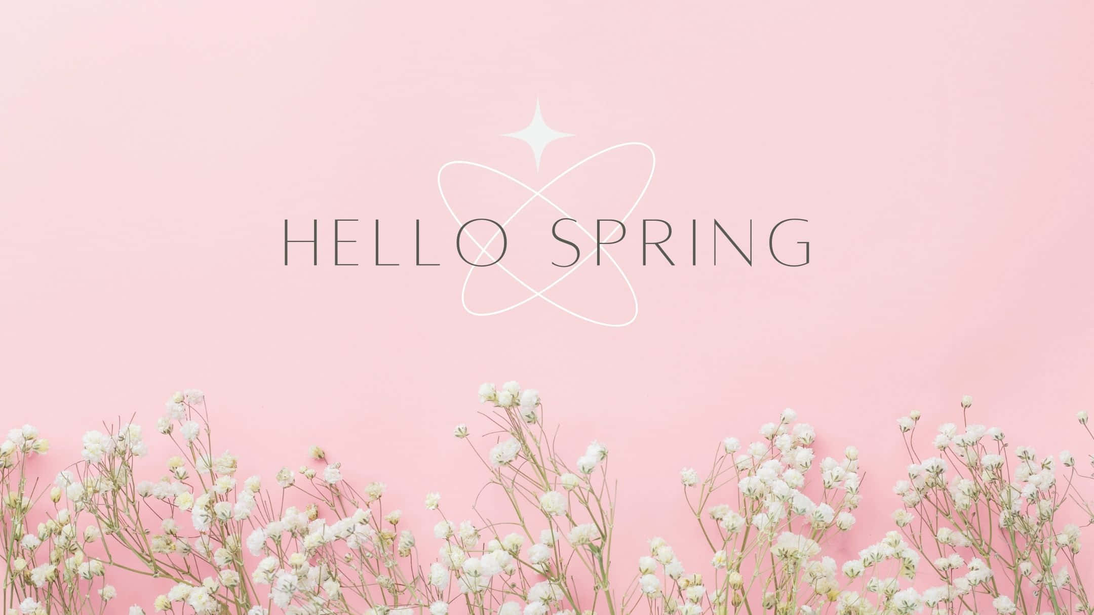 Spring Aesthetic 桌布 壁紙 — 柔和粉紅色背景，以精緻的白色滿天星花朵圍繞「hello spring」文字，並帶有閃爍的原子設計。