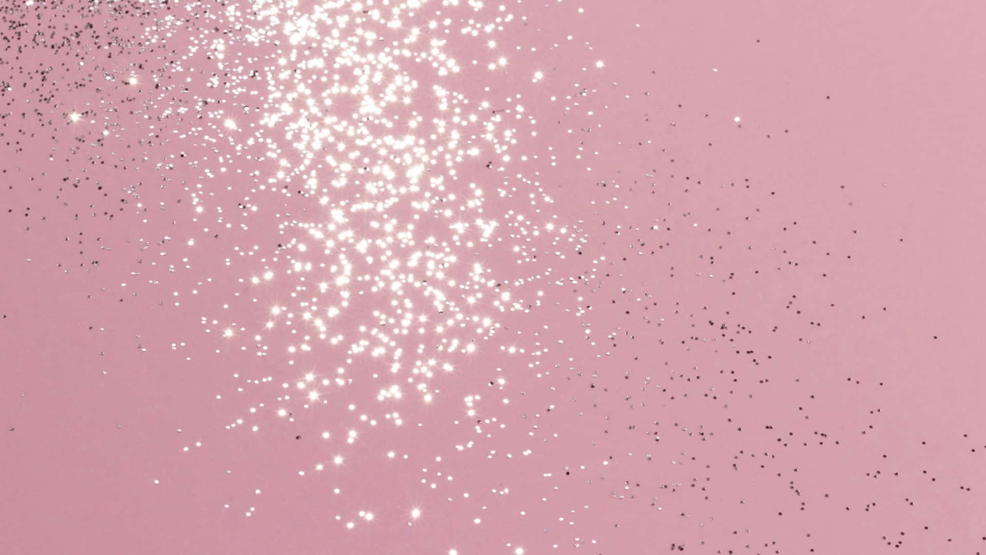 Pink Sparkles 桌布 壁紙 — 柔和粉紅色背景，飾有閃閃發光的白色和黑色亮粉粒子，呈對角線飄散。