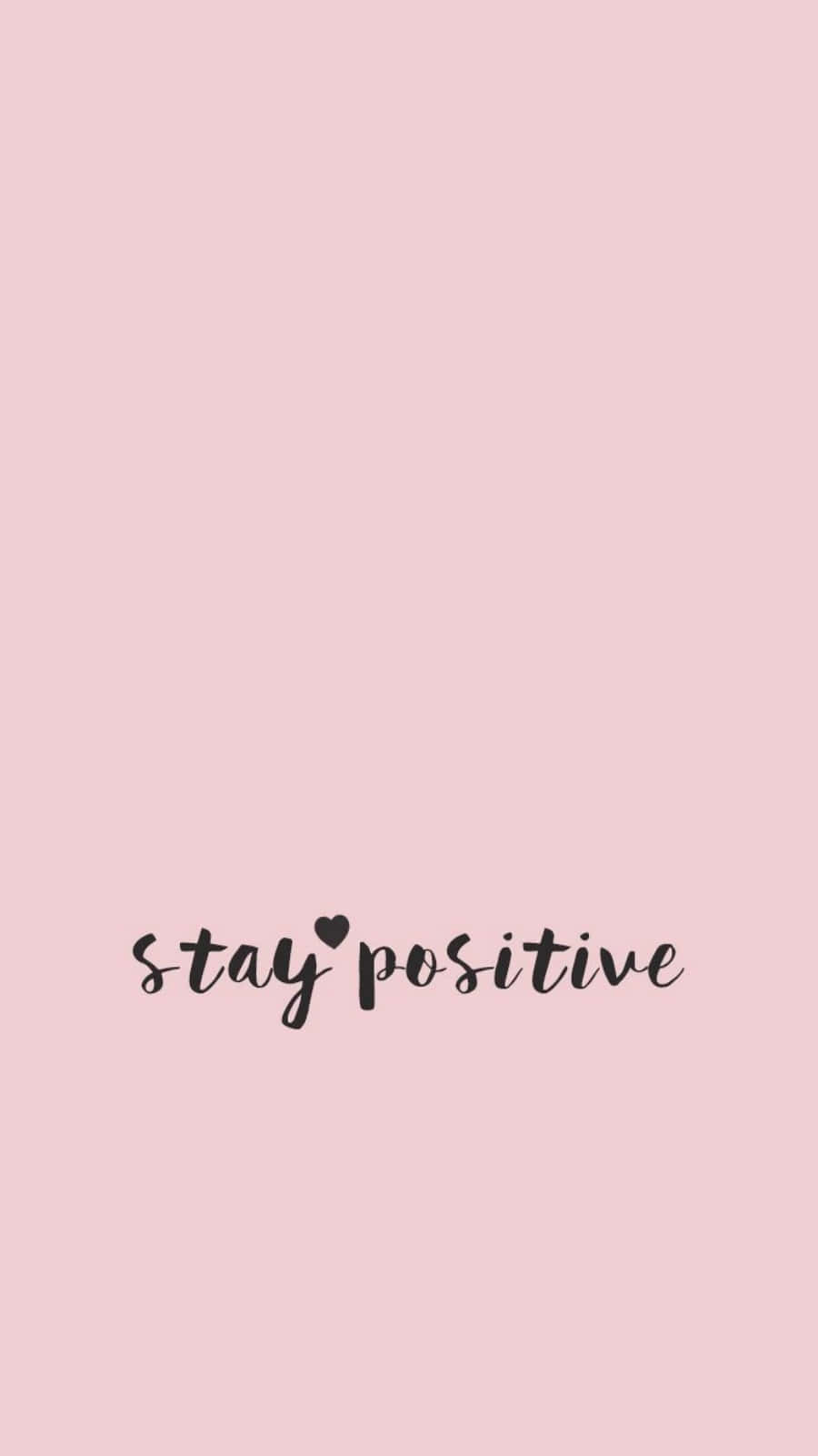 少女風 桌布 壁紙 — 柔和粉紅色背景，黑色草書文字寫著 stay positive，並用心形取代字母 i 上方的點。