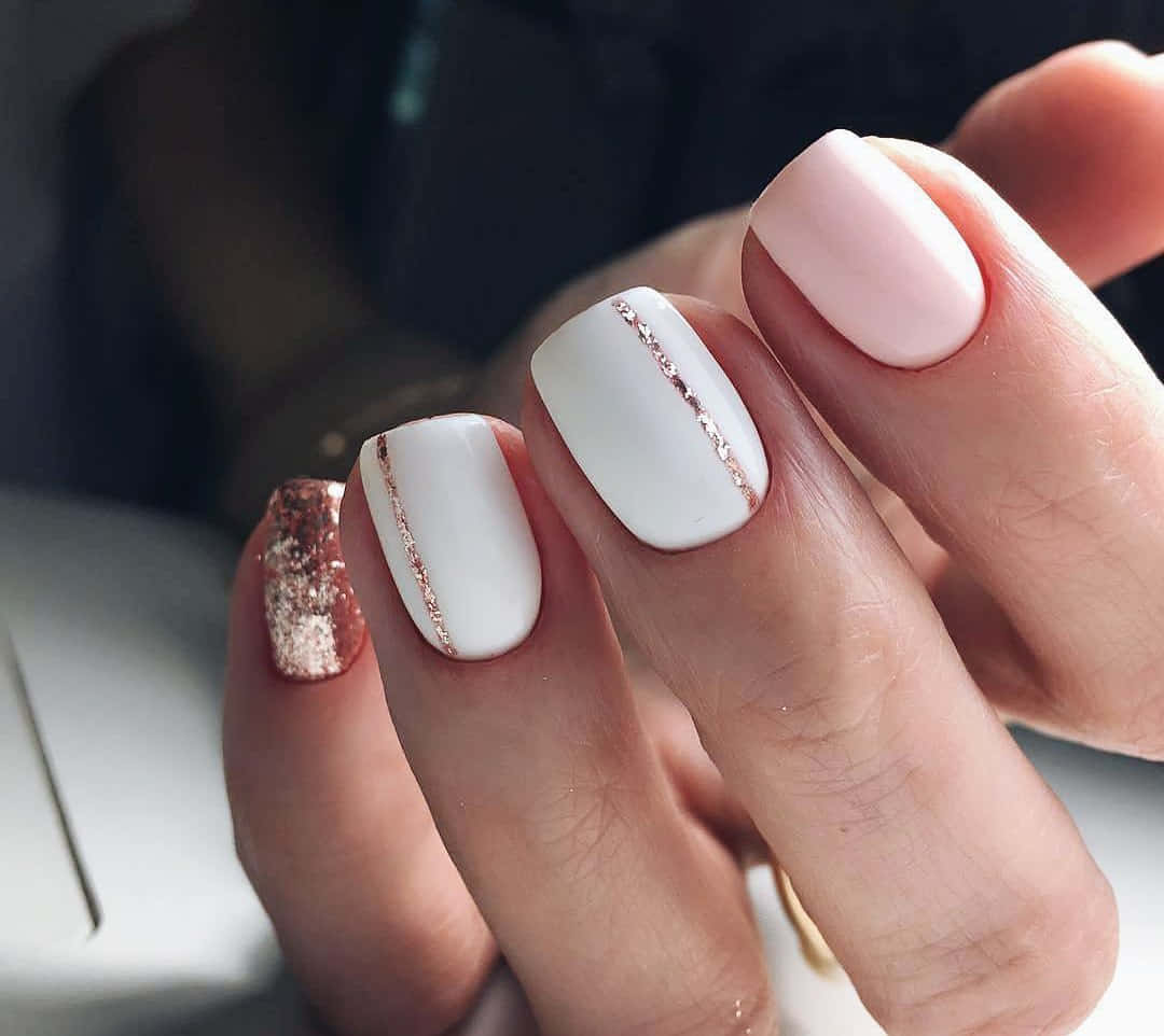 Spring Nails 桌布 壁紙 — 柔和粉紅色背景上，優雅美甲的特寫，帶有白色啞光指甲油和玫瑰金閃粉點綴。