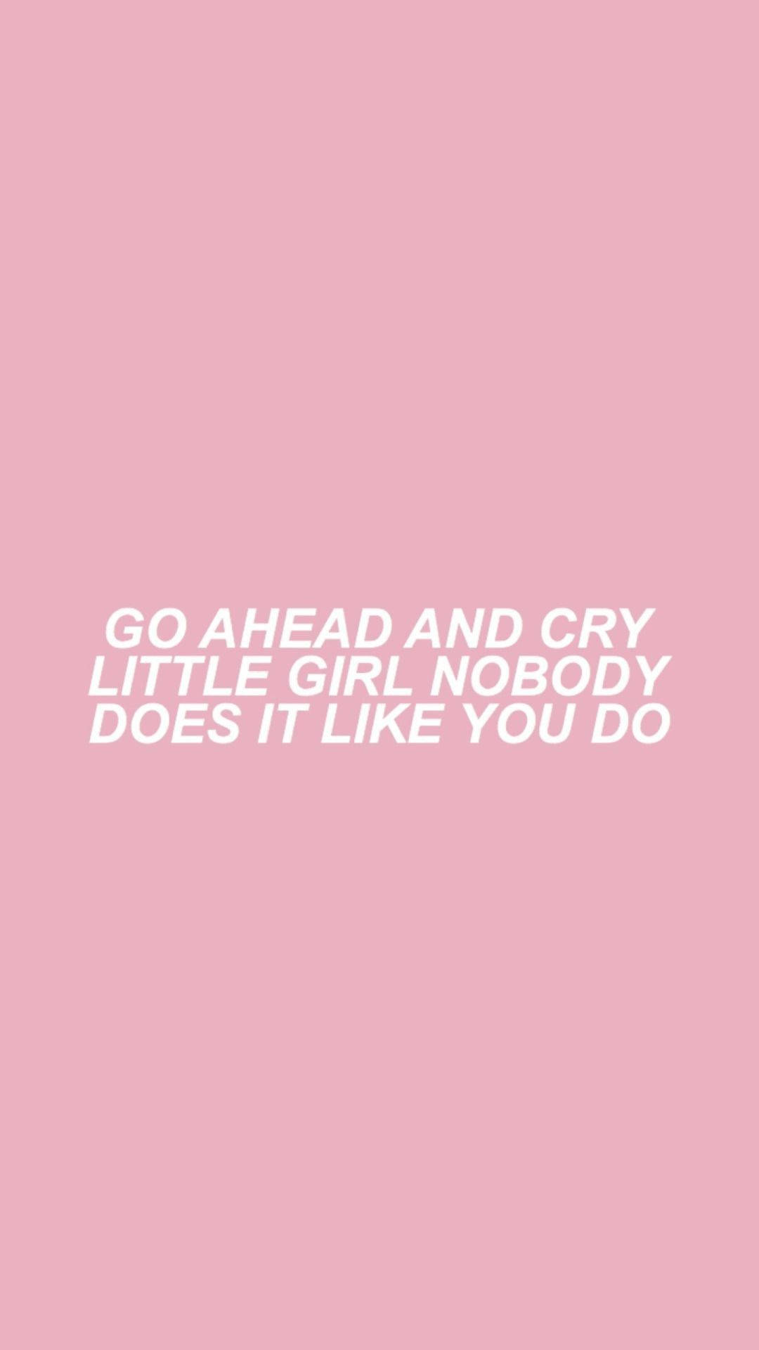 桌布 壁紙 — 柔和粉紅色背景上，有粗體白色文字寫著「GO AHEAD AND CRY LITTLE GIRL NOBODY DOES IT LIKE YOU DO」。