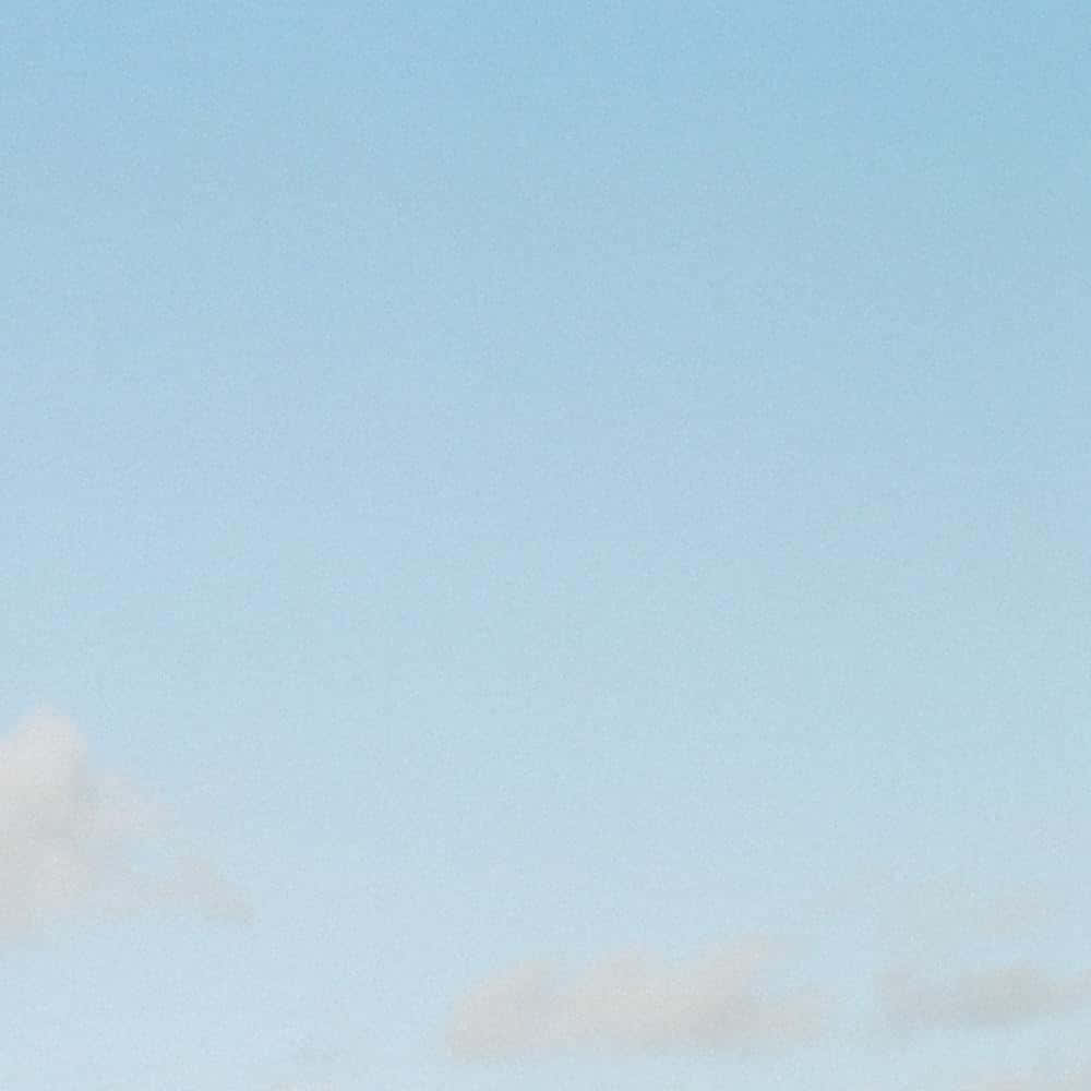 攝影 桌布 壁紙 — 柔和粉藍色天空，薄薄的白雲輕輕飄過地平線。