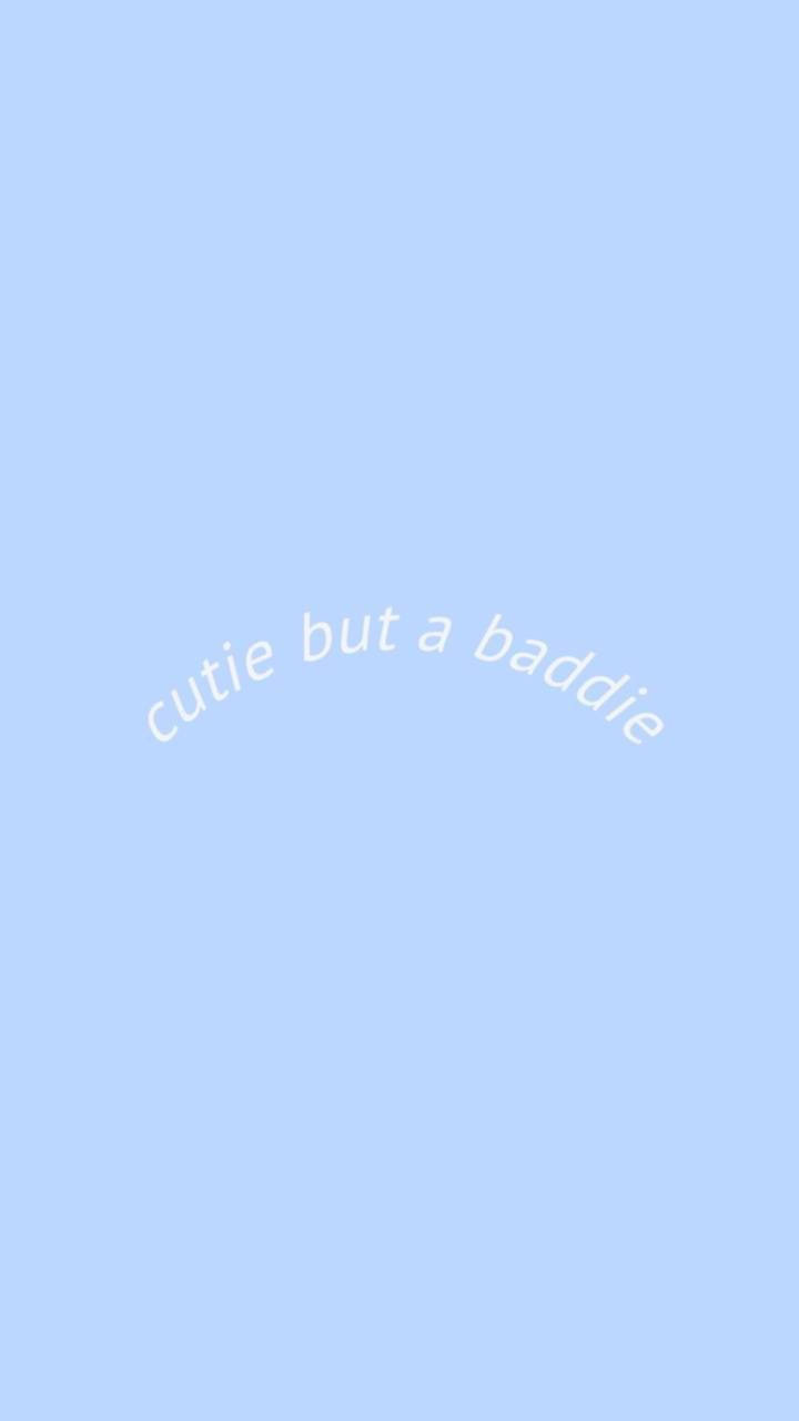 iPhone 壞女孩 桌布 壁紙 — 柔和粉藍色背景，帶有彎曲的白色文字，寫著 cutie but a baddie。