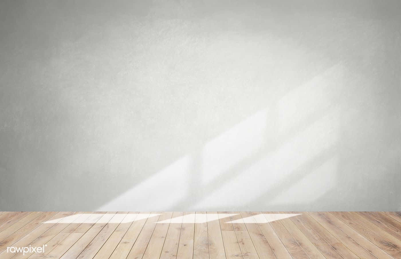 Empty Room 桌布 壁紙 — 柔和自然光在空無一物的極簡房間中，於有紋理的灰色牆壁和淺色木地板上投射出幾何陰影。