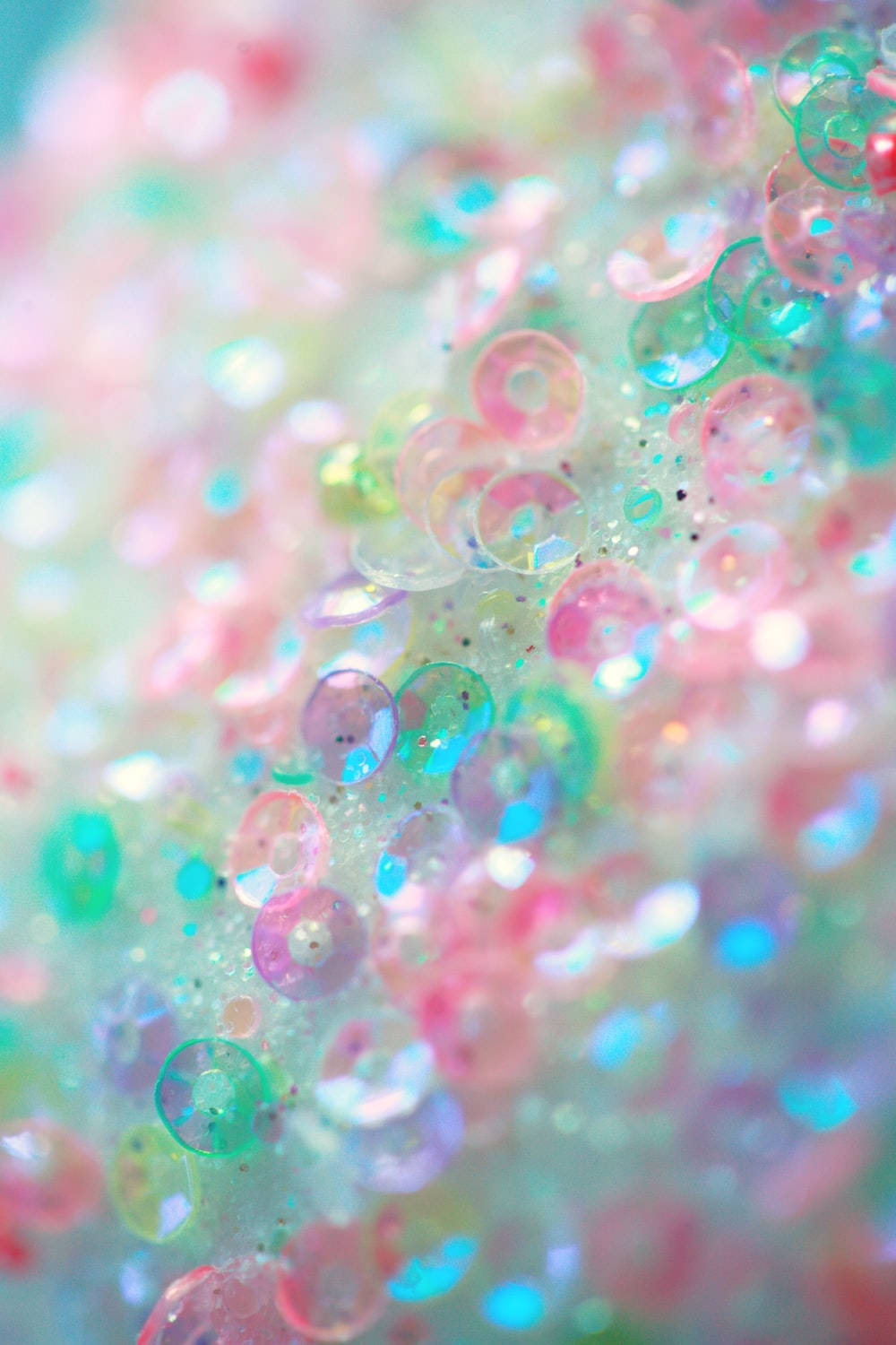 Sparkle 桌布 壁紙 — 柔和色調半透明珠子的特寫，帶有閃閃發光的亮片，營造出夢幻而柔和的抽象紋理。