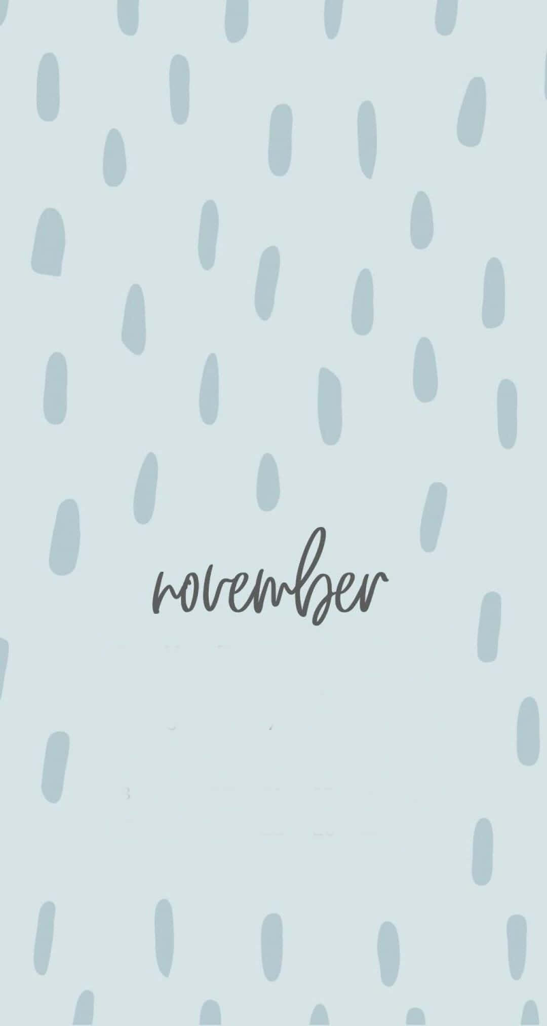 Aesthetic November 桌布 壁紙 — 柔和藍色背景，散落灰色淚滴形狀，並以優雅草書寫上november一詞。