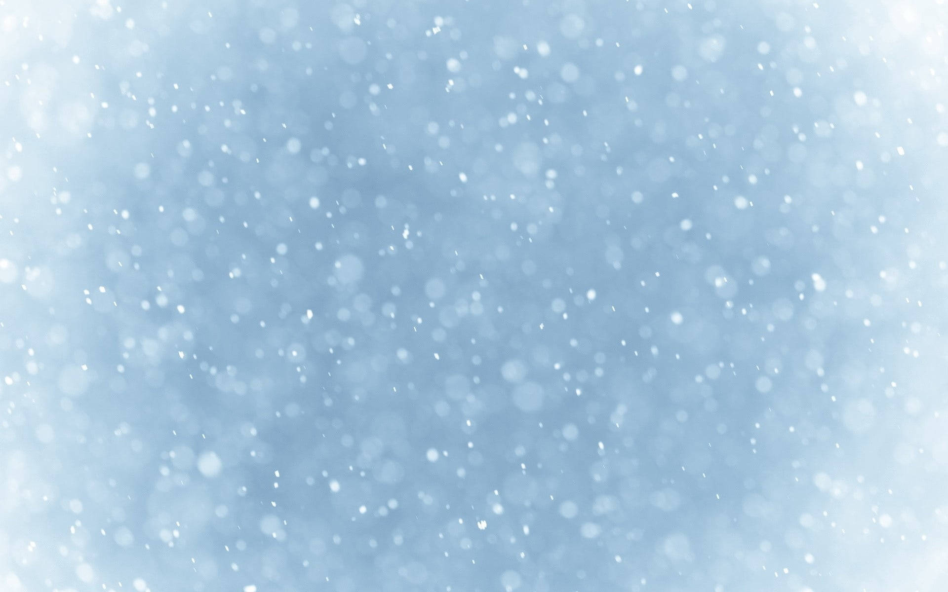 雪花在柔和的藍色冬日天空中輕輕飄落。 — 雪花 GIF 壁紙